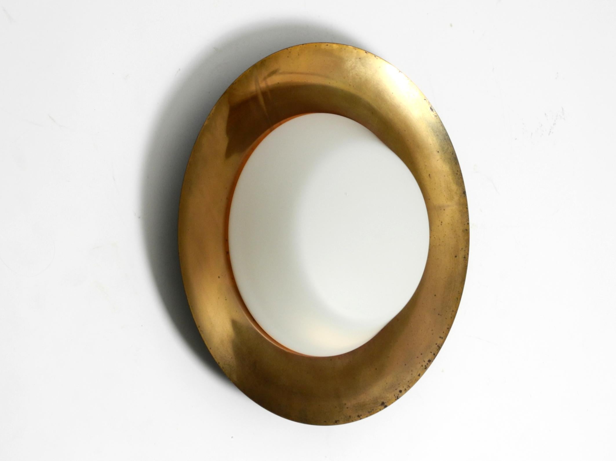 Grande applique ou plafonnier Mid Century en verre avec réflecteur en métal plaqué laiton.
Superbe design minimaliste, typique des années 1950. Le fabricant est Kaiser Leuchten. Fabriqué en Allemagne.
La face avant est recouverte d'une couche de