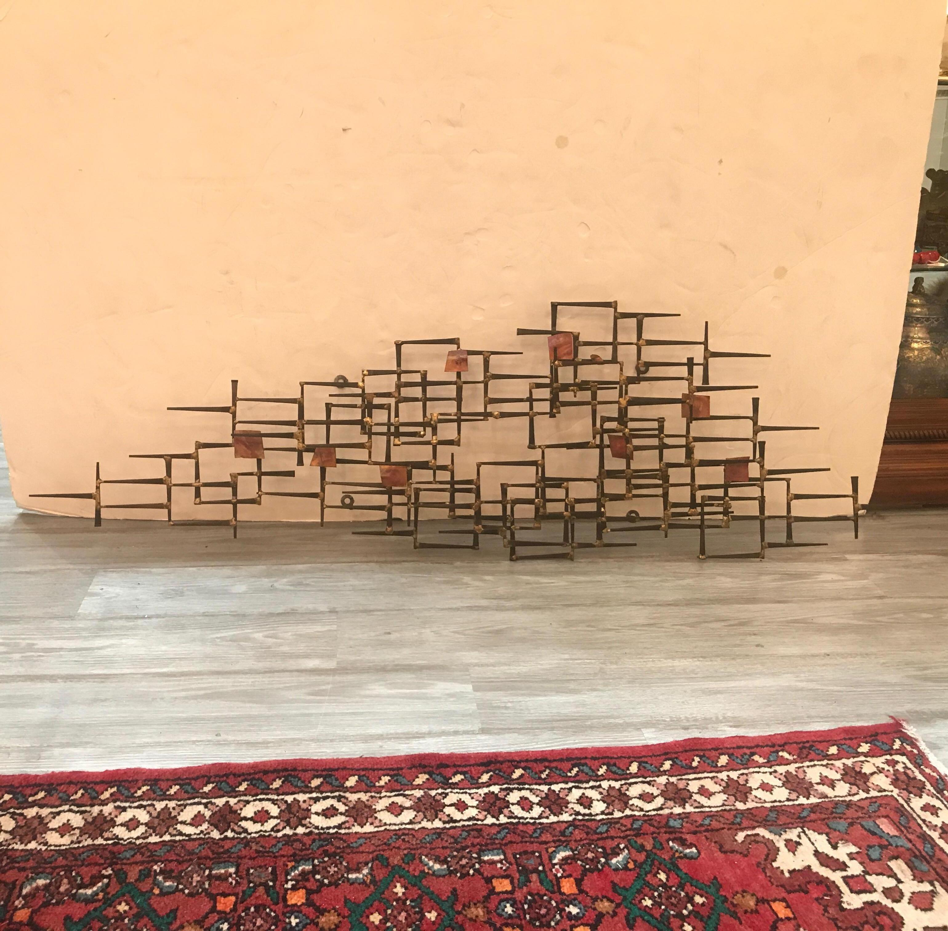 1960s metal wall hanging by Degroot. The sculpture made of welded rough flat nails with copper square tags. This piece is signed on the lower left on a small copper attached label.