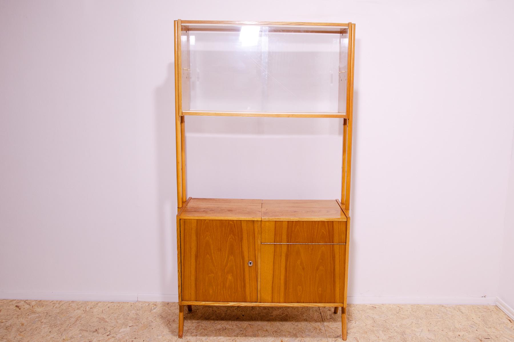 Mid century Vintage bookcase from the 1960´s. It was designed by František Jirák for Tatra nábytok in the former Czechoslovakia. Features a simple design, a glazed section with a storage space and pull-out section usable as a bar.

In very good