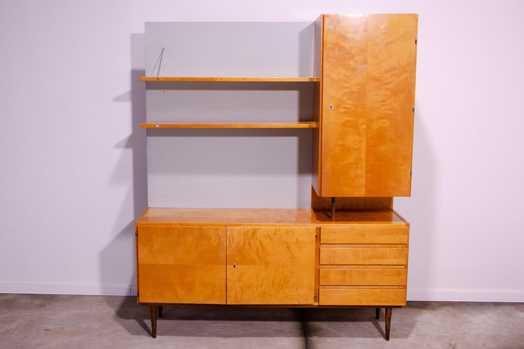 Mid century wall shelf cabinet from the 1960´s. It was by UP Závody in the former Czechoslovakia.
It can also be used as a chest of drawers or a bookcase.
It´s made of beechwood, ashwood and plywood.
In good preserved condition, it shows signs of