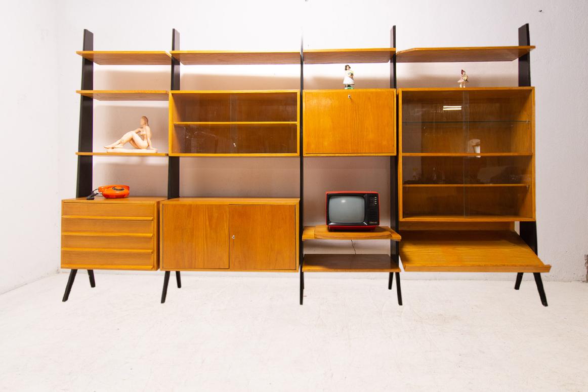 Midcentury wall shelf system from the 1960s. It was designed in the former Czechoslovakia. It was renovated, in very good condition.
It can also be used as a chest of drawers, a bar or a bookcase.
It´s made of beechwood, plywood and iron.
It