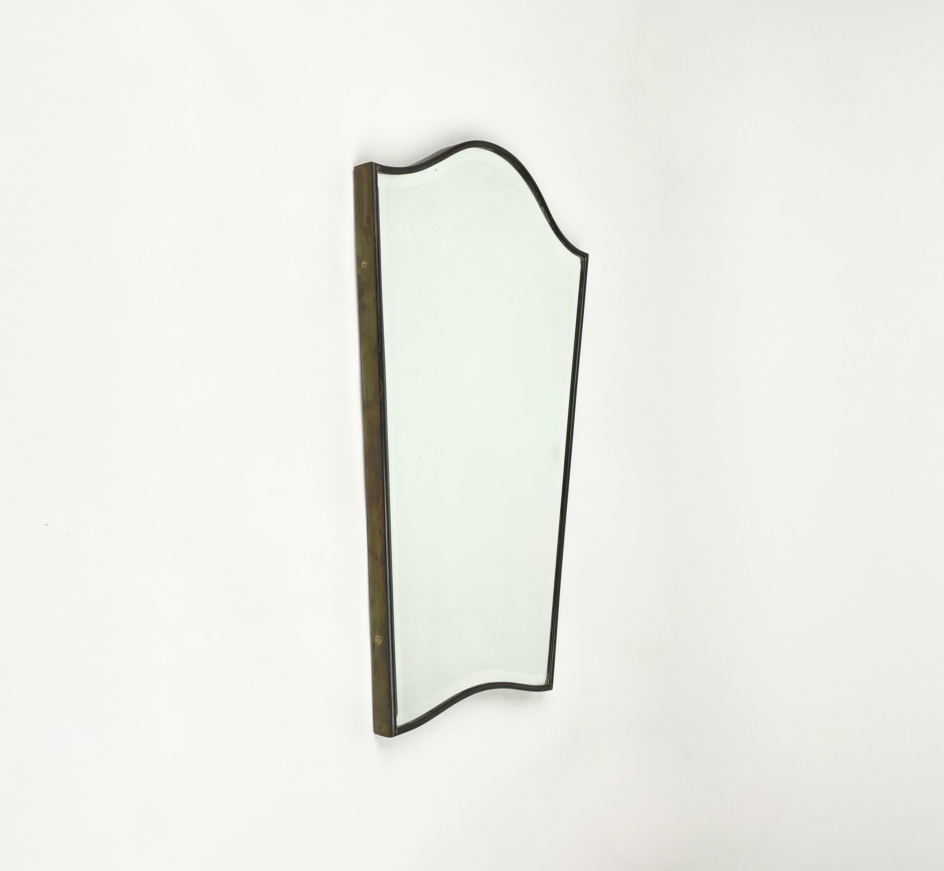 Wall mirror in the shape of a shield framed with brass in the style of the Italian designer Gio Ponti. 

Made in Italy in the 1950s.