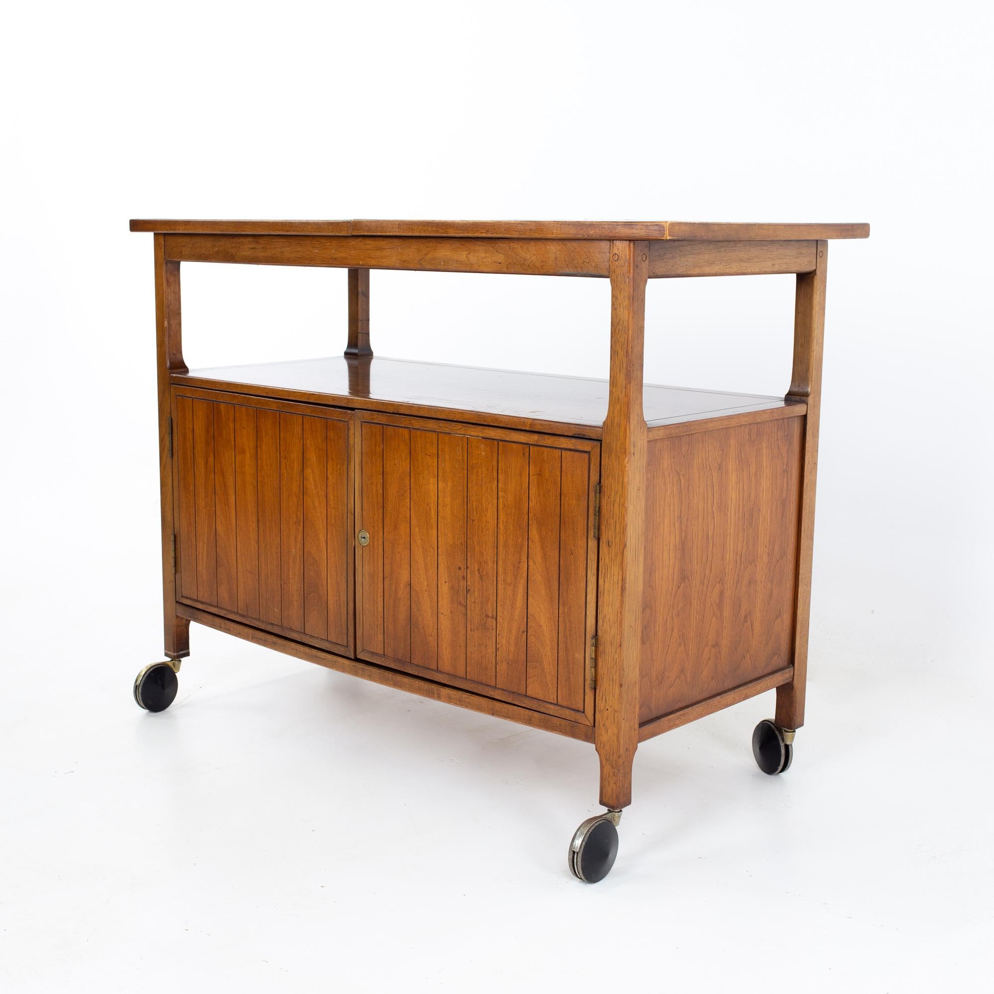 Mid century walnut and black laminate expanding bar cart
Bar cart measures: 40.25 wide x 18 deep x 30.75 inches high, when expanded, the cart is 57 inches wide

All pieces of furniture can be had in what we call restored vintage condition. That