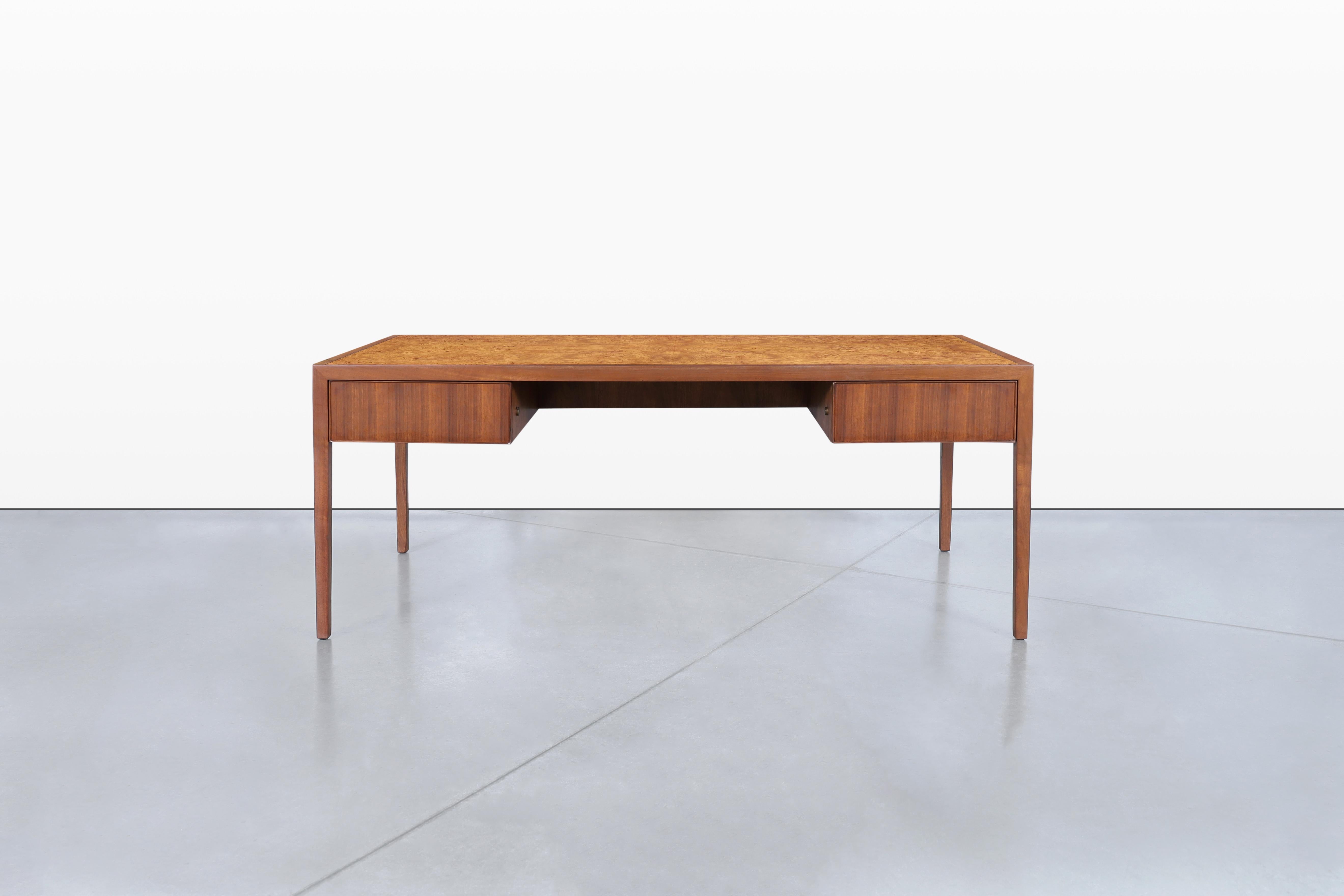 Una splendida scrivania direzionale moderna di metà secolo, realizzata con maestria da Stow & Davis negli anni '60 negli Stati Uniti. Questo pezzo presenta un bellissimo piano in legno di radica, elegantemente rivestito in ricco noce, creando un