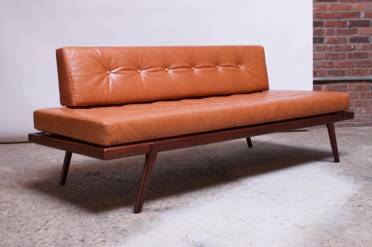 Daybed / settee designed by Mel Smilow for Smilow-Thielle in the 1950s. Solid walnut construction with newly upholstered Ralph Lauren leather cushions featuring button-tufted detail. Additionally, a Ralph Lauren brown suede lining has been fitted to