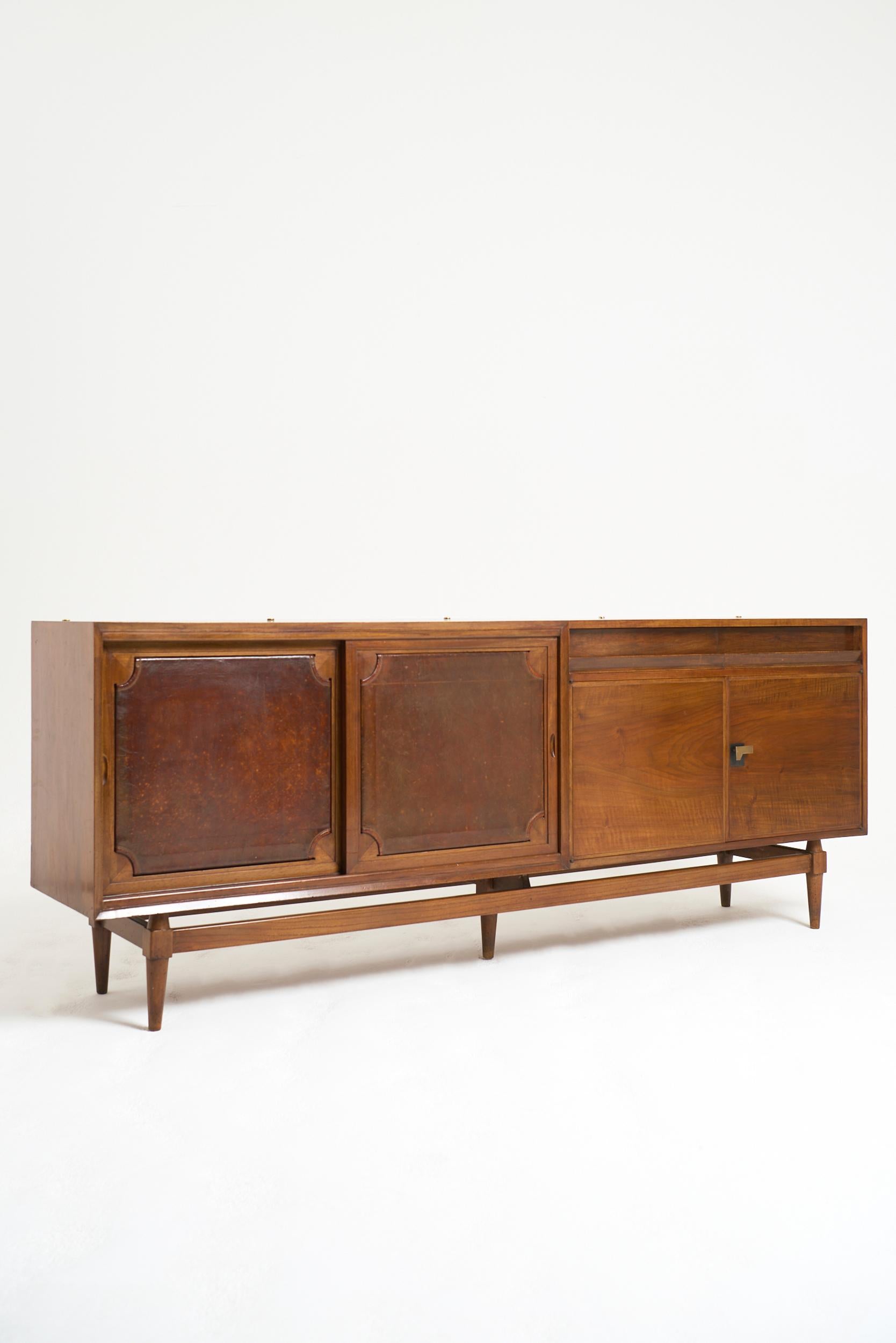 A walnut and brown leather sideboard
Italy, Circa 1950

