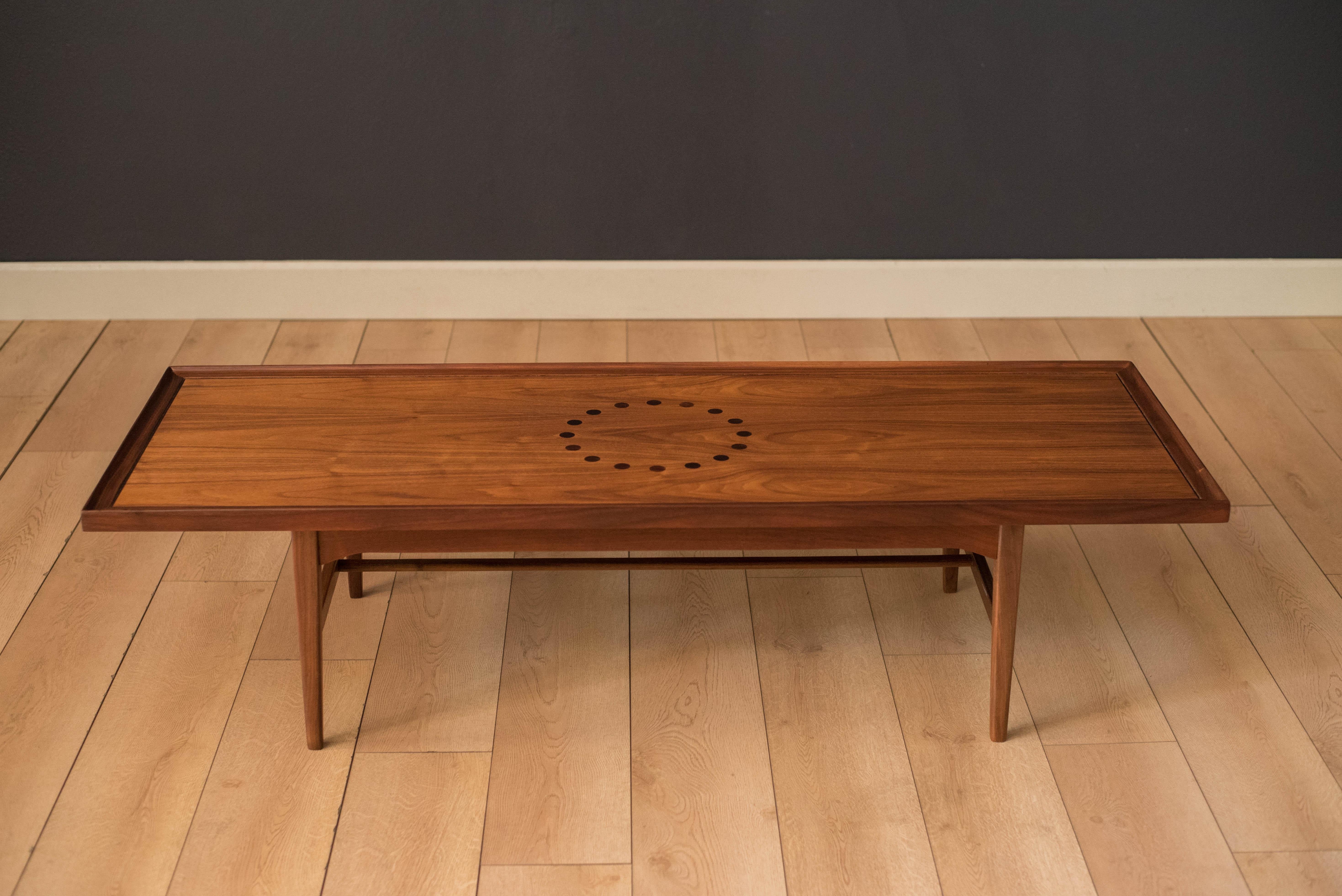 Vintage coffee table from the Declaration collection designed by Kipp Stewart & Stewart McDougall for Drexel Furniture Co. in walnut. This piece features rosewood inlay and a raised edge tabletop. Supporting base is constructed with tapered legs and