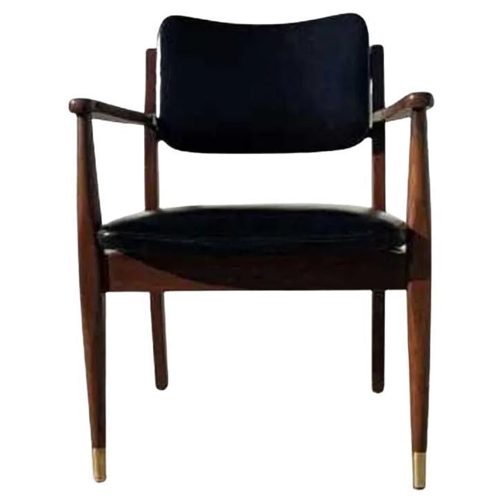 Un élégant fauteuil du milieu du siècle, fabriqué à partir d'un cadre en noyer massif, avec un luxueux cuir italien pleine fleur semi-aniline noir pour l'assise et l'avant du dossier. Les pieds avant coiffés de laiton ajoutent un détail raffiné.

Un