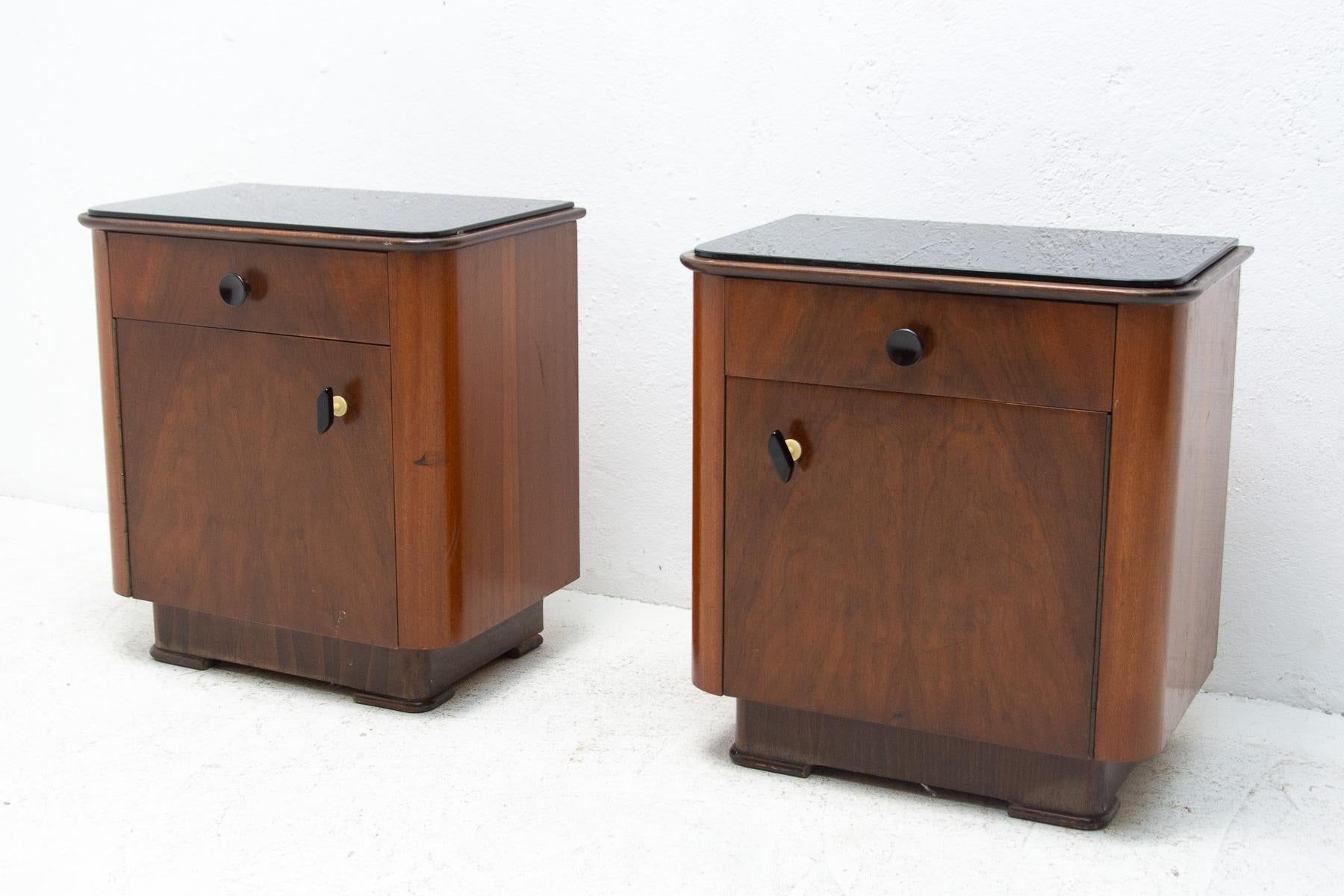 These night stands were made by UP Zavody in the former Czechoslovakia in the 1960´s. They are made of walnut wood and black opaque glass on the top. The stands are in good Vintage condition, bears signs of age and using. Price is for the