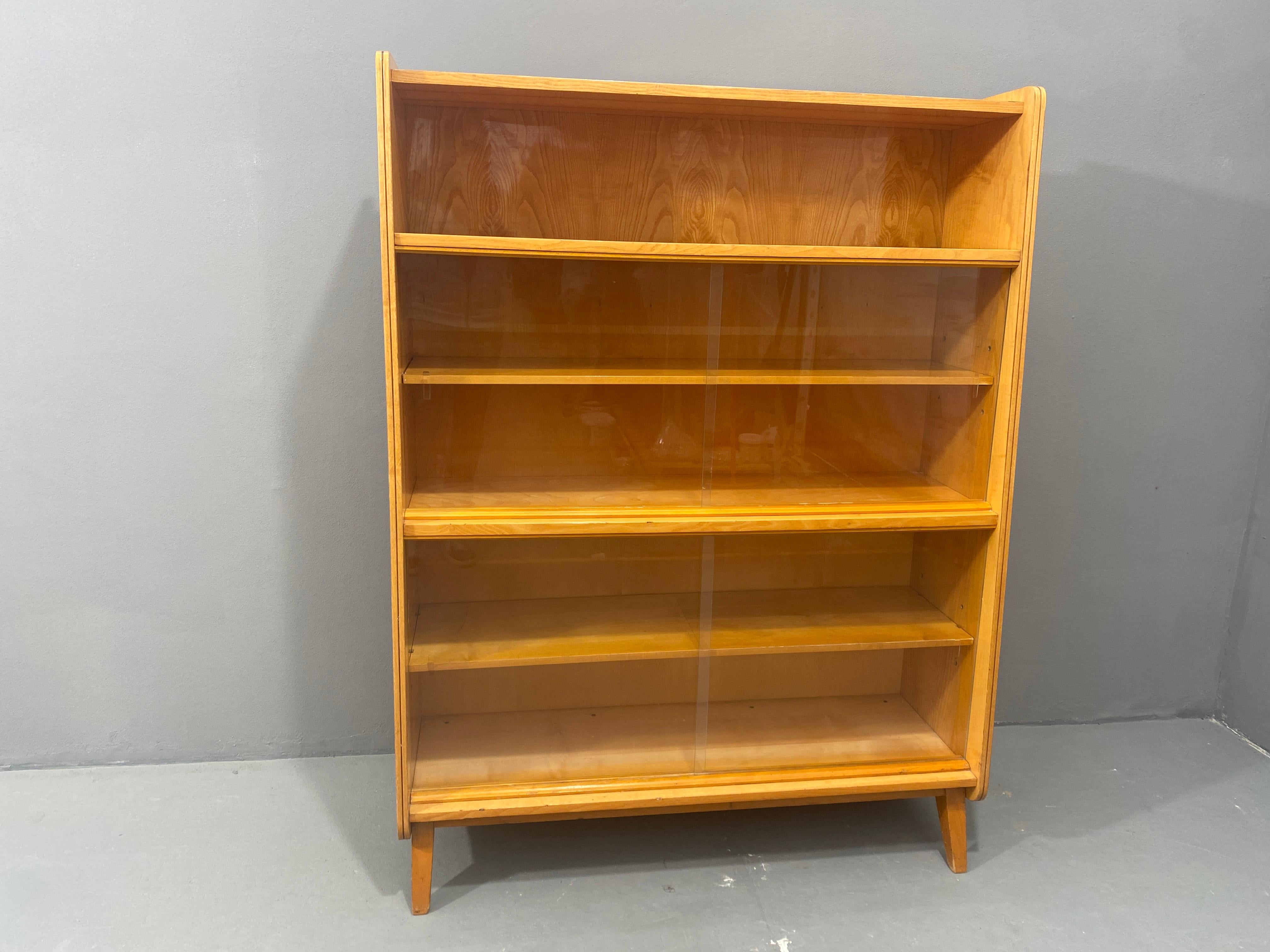 Libreria vintage di metà secolo, risalente agli anni '60. È stato progettato da František Jirák e prodotto dall'azienda Jitona nell'ex Cecoslovacchia. Presenta un design semplice, una sezione vetrata con cinque vani portaoggetti. Complessivamente in