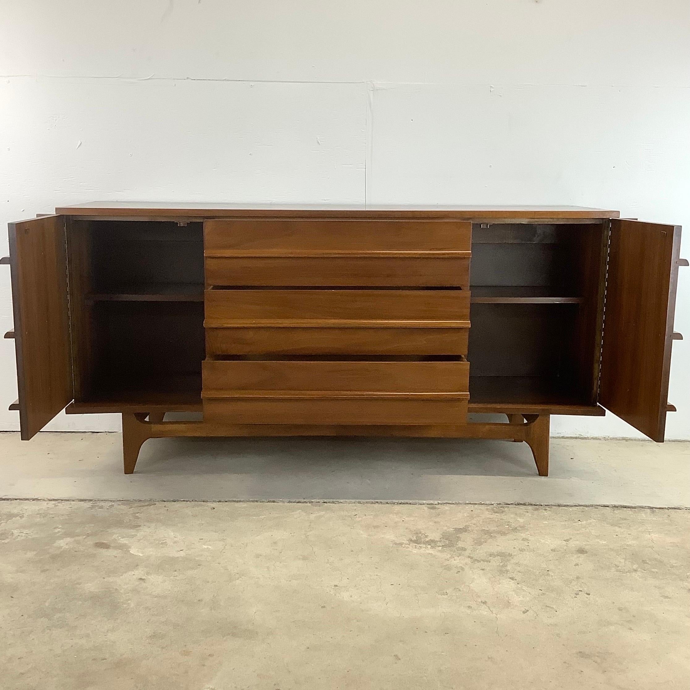 This Young Manufacturing Walnut Bow Front Credenza showcases the timeless appeal of this quality mid-century design, making it a remarkable centerpiece in any room.

Crafted with exceptional artistry, this credenza features a distinctive curved bow
