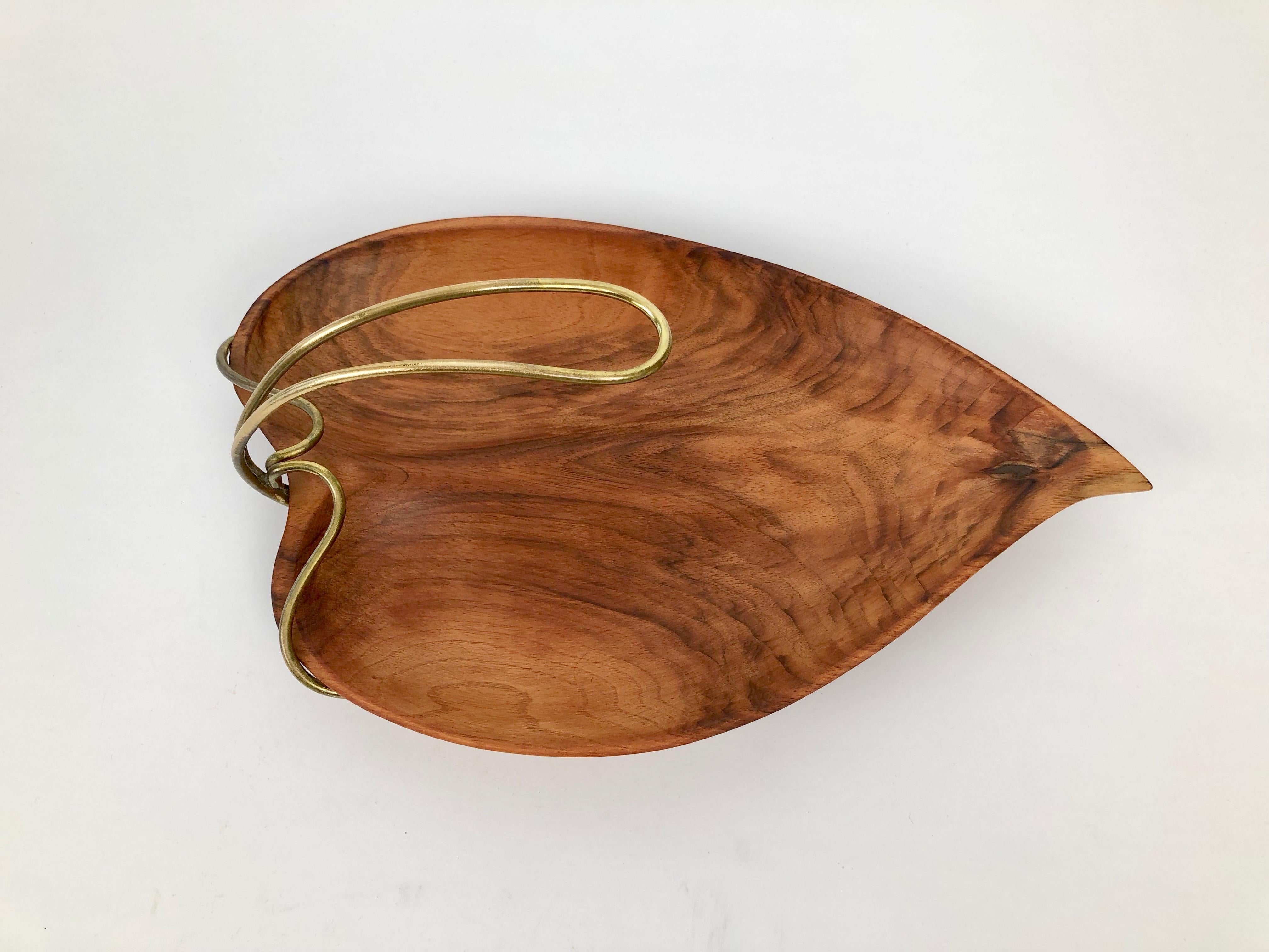 This is a beautiful, hand carved wooden bowl in the shape of a leaf. You have to see it in person to appreciate its elegance. Holding it in the hand and feeling the silky smoothness of the polished walnut is a sensation.

The original oil finish