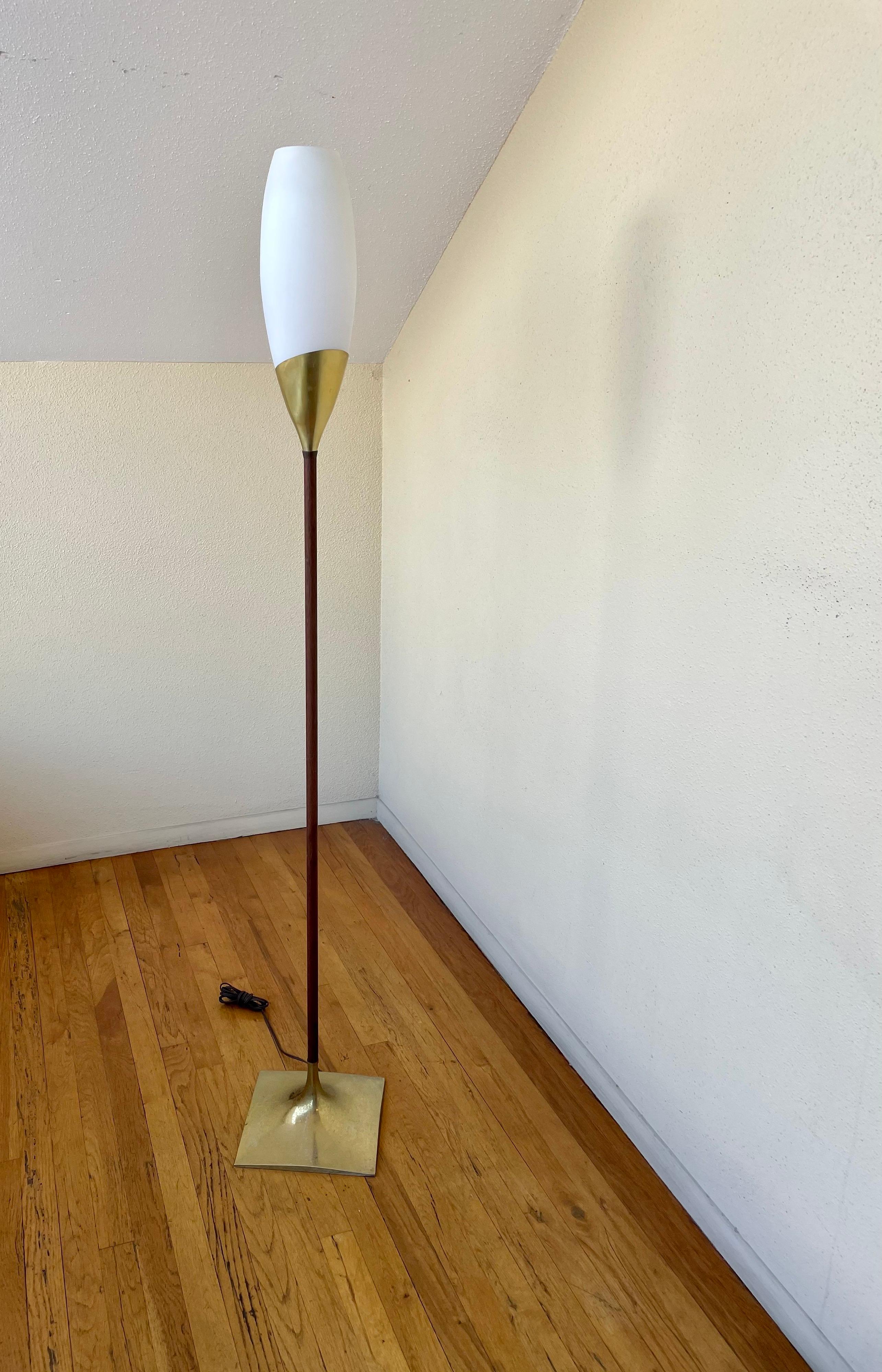 Mid-Century Modern floor lamp with tulip frosted Italian glass shade, circa the 1960s. This piece features a unique walnut stem and a sculptural brass finished base. Equipped with a three-way switch.