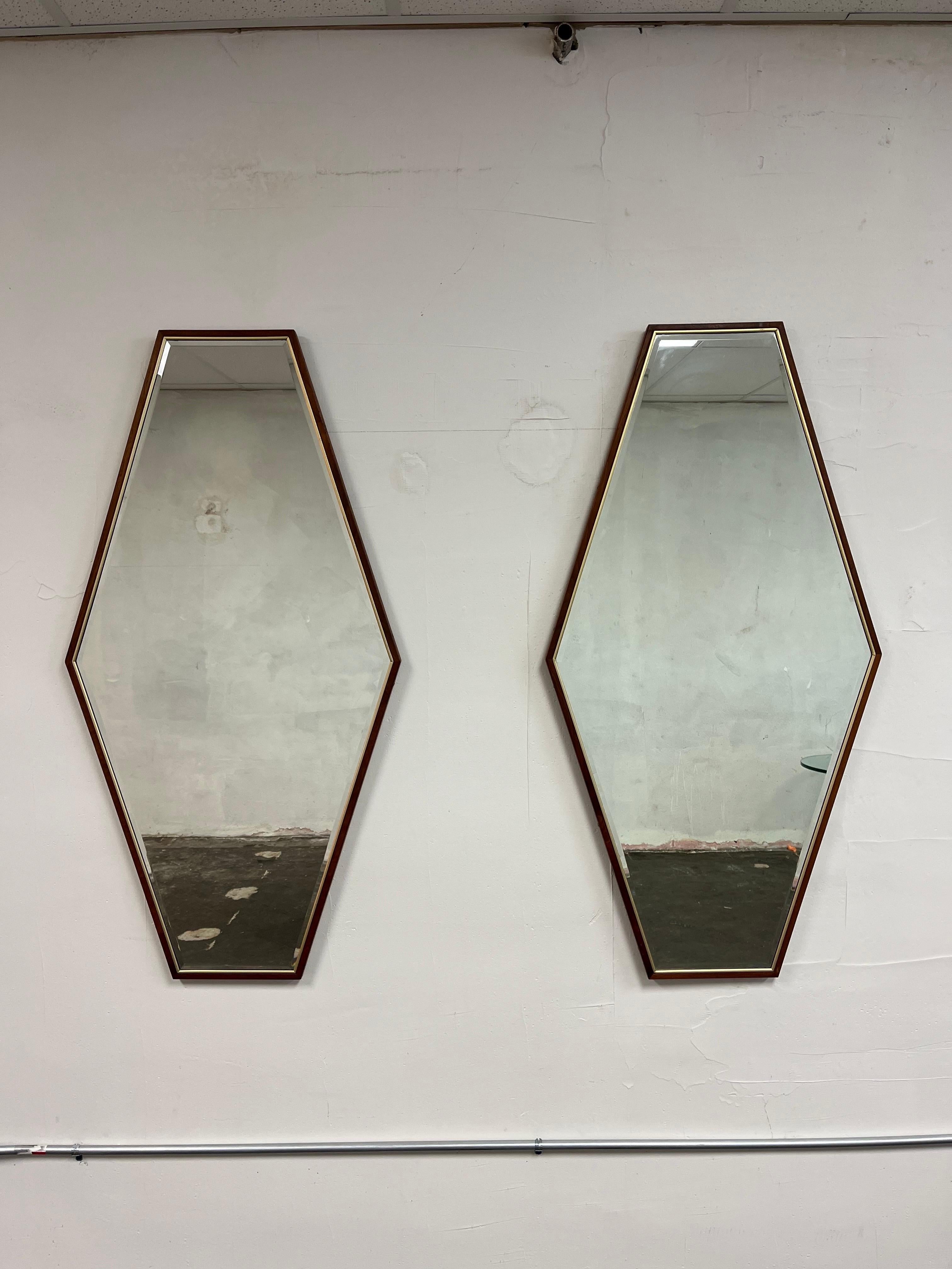 Quality vintage solid walnut frame wall mirrors. Features an inset brass border, hexagon solid wood frame, and beveled glass mirror. The construction is very nice and the design is similar to the works of Paul McCobb. Would look great hanging