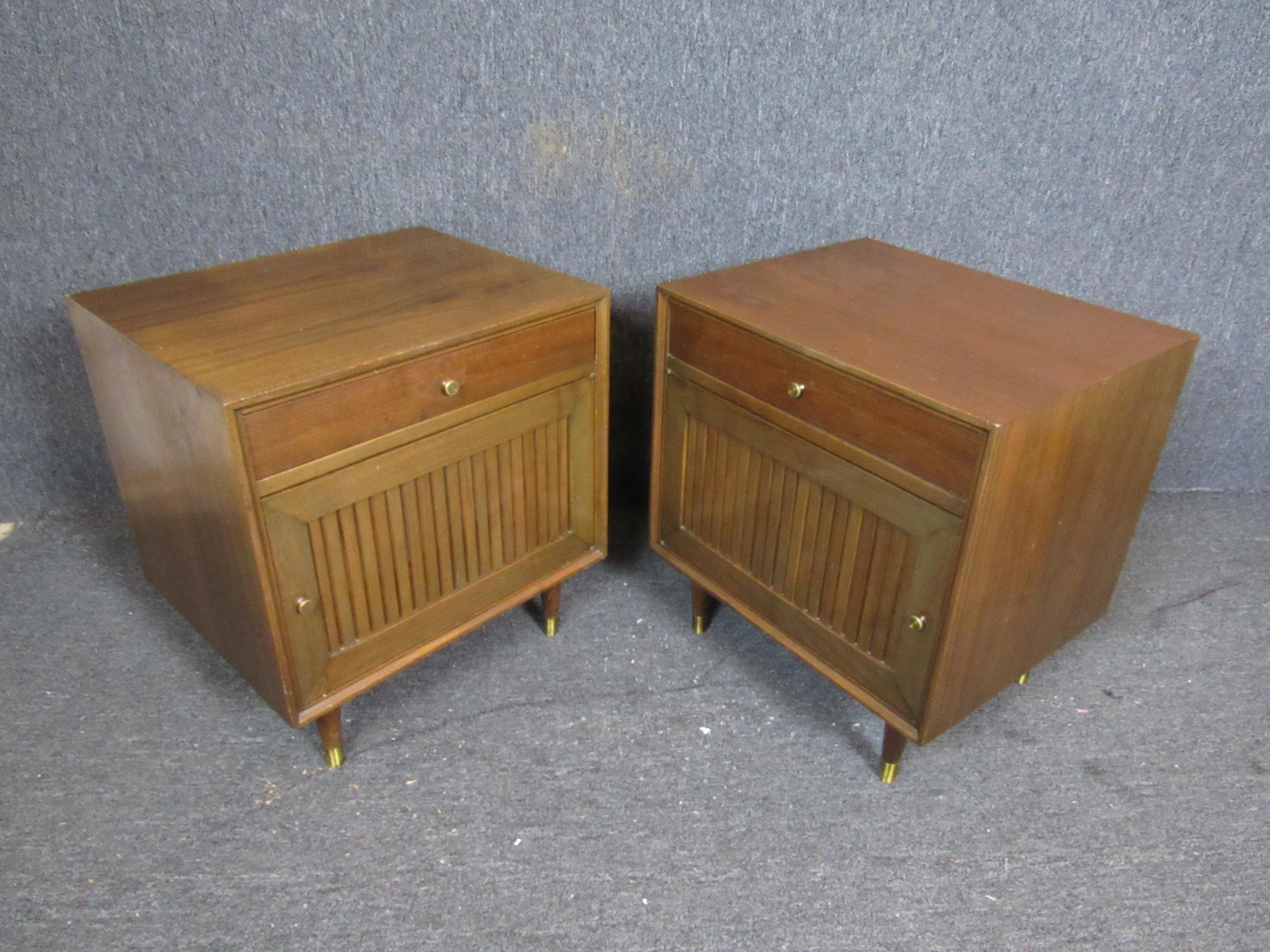 Fantastic pair of vintage Mid-Century Modern walnut and brass nightstands designed by Mark Furst and Robert Fellner for Furnette Inc. in New York. Terrific natural wood grain is accented by minimalist brass hardware, while planked front doors add