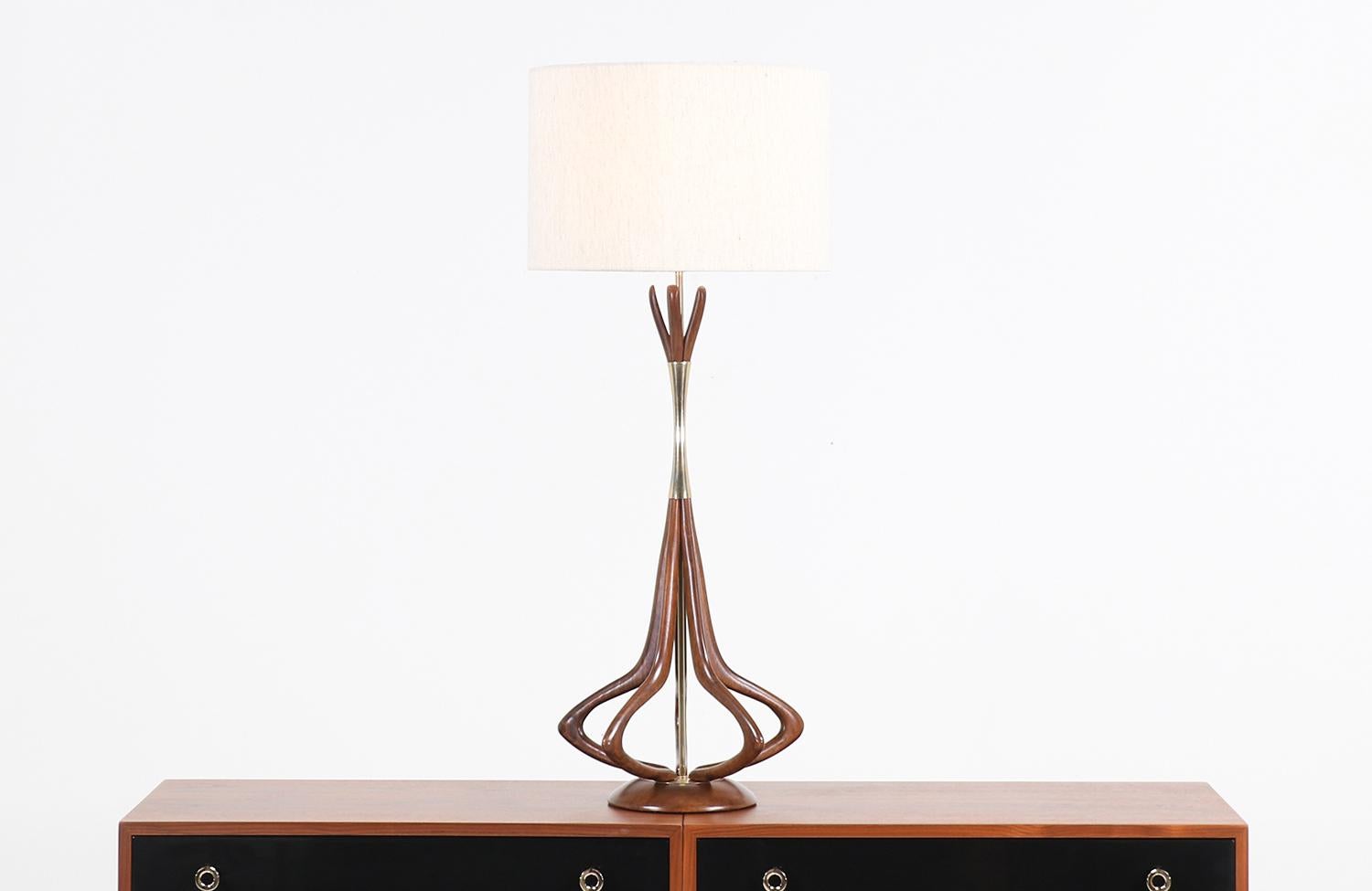 Stylish sculpted modern table lamp designed and manufactured by Modeline of California in the United States, circa 1960s. This 3-dimensional desk lamp features a sculpted walnut wood body with five vertical prongs that are joined in the upper part