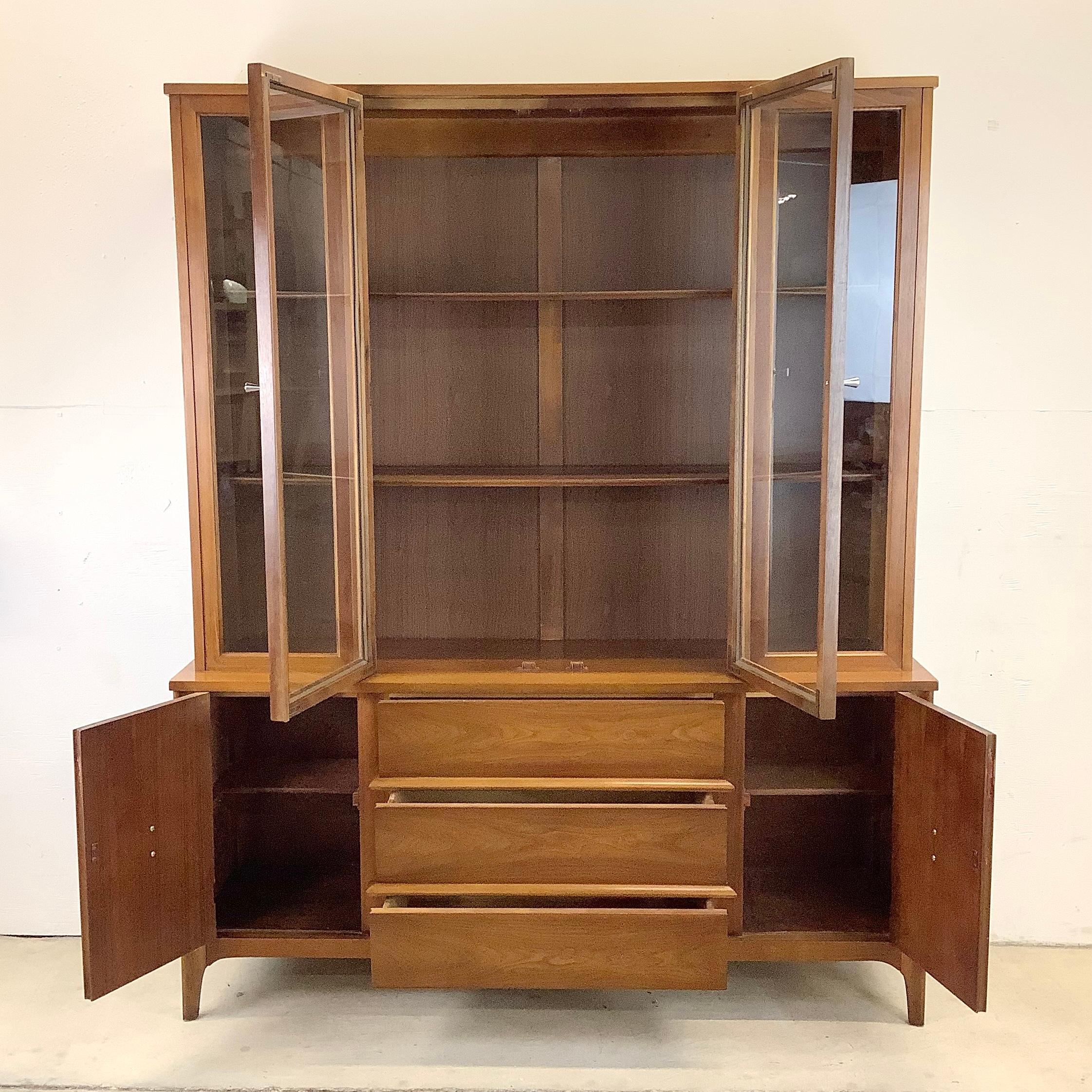 This beautiful mid-century sideboard with china cabinet hutch top features exquisite mix of walnut finish and subtle modern design. This single piece sideboard combines china cabinet top with lower mix of drawers and cabinet space, offering the