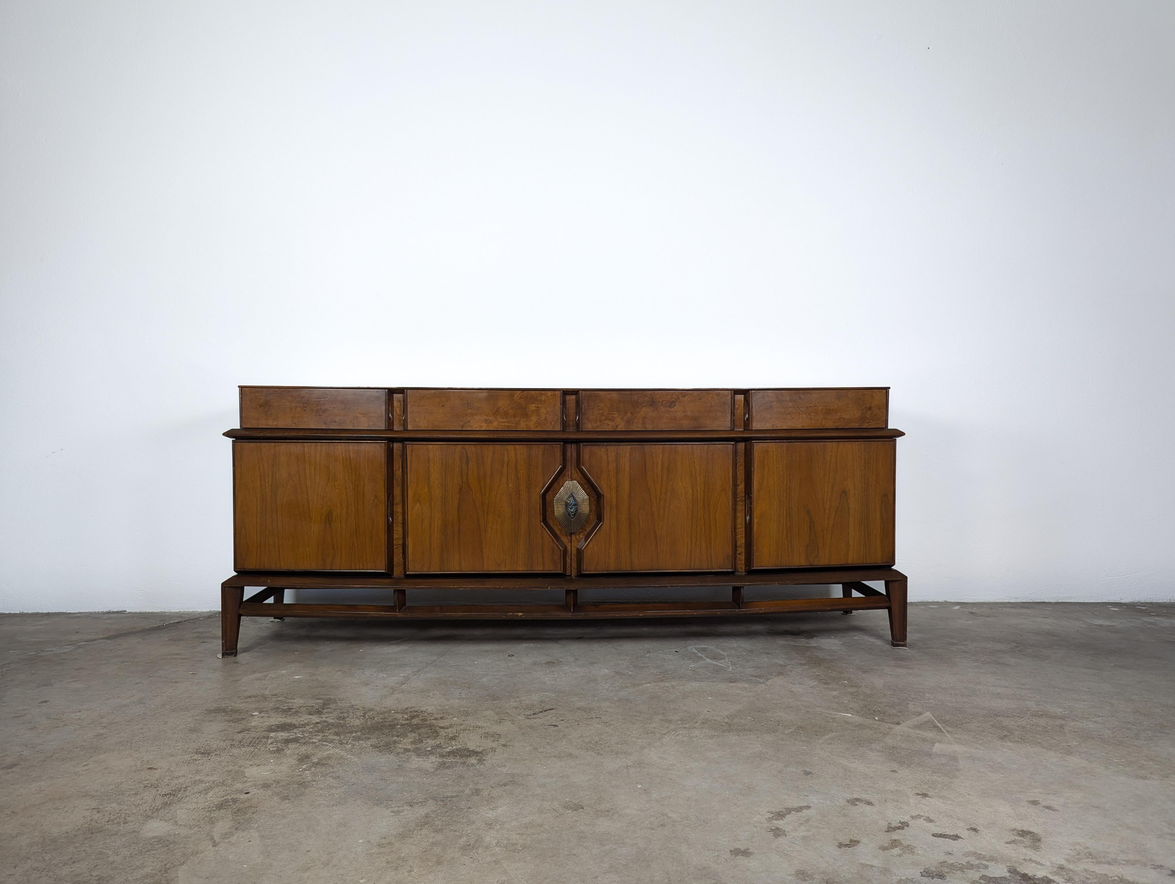 Elevate your home decor with this stunning vintage mid-century modern credenza, designed by the iconic duo Helen & Hobey Baker in the 1960s. This versatile piece doubles as a dresser or buffet, featuring a beautiful walnut frame in its original