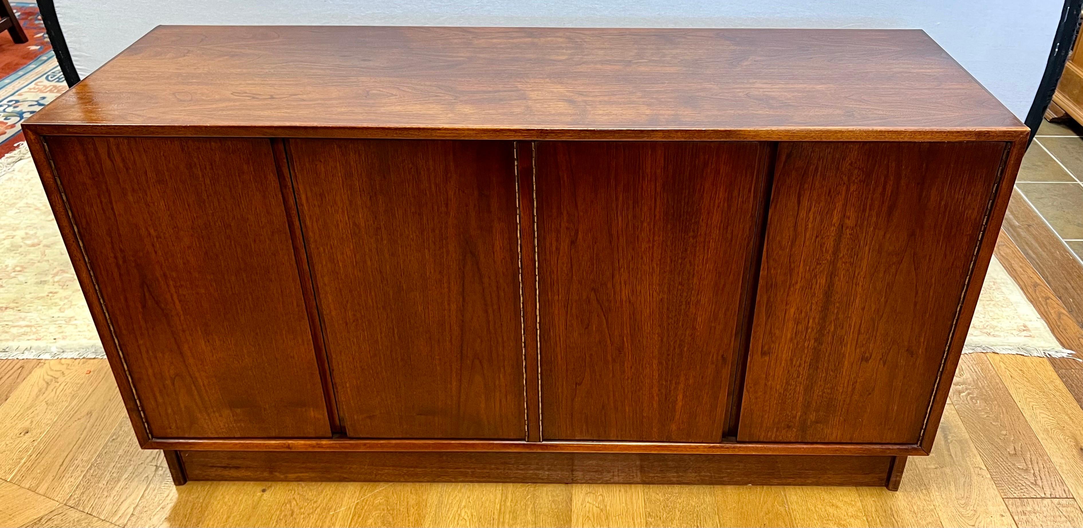 Vintage mid century walnut credenza features four doors that open to plenty of storage. Cabinet has been polished to bring out the beautiful wood graining. Great scale and better lines. Why not own the good stuff. Made in USA by Foster-McDavid,