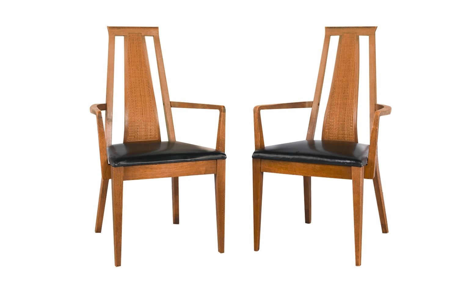 Stunning set of six beautiful Mid Century Modern Walnut dining chairs, two arm chairs and four side chairs by American of Martinsville. The solid walnut frames feature modern styling with a distinct beautiful design. Sculpturally carved caned high