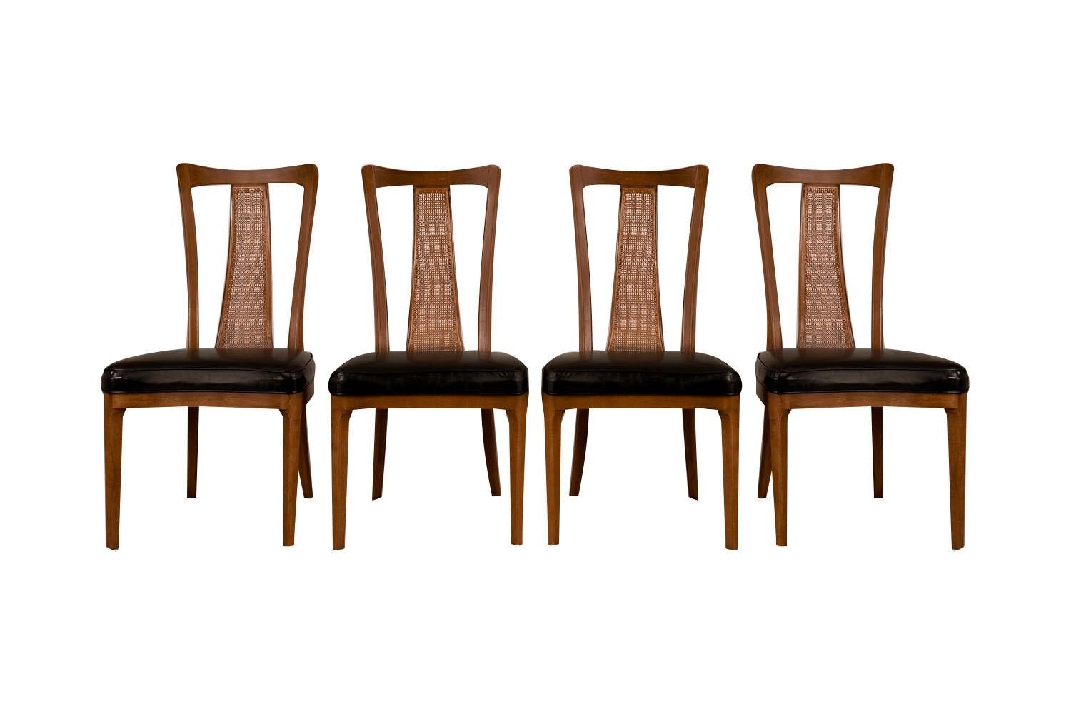 Stunning set of six beautiful Mid-Century Modern Walnut dining chairs, two armchairs and four side chairs. The beautiful walnut frames feature modern styling with a distinct beautiful design. Sculpturally carved caned high backrests with tapered