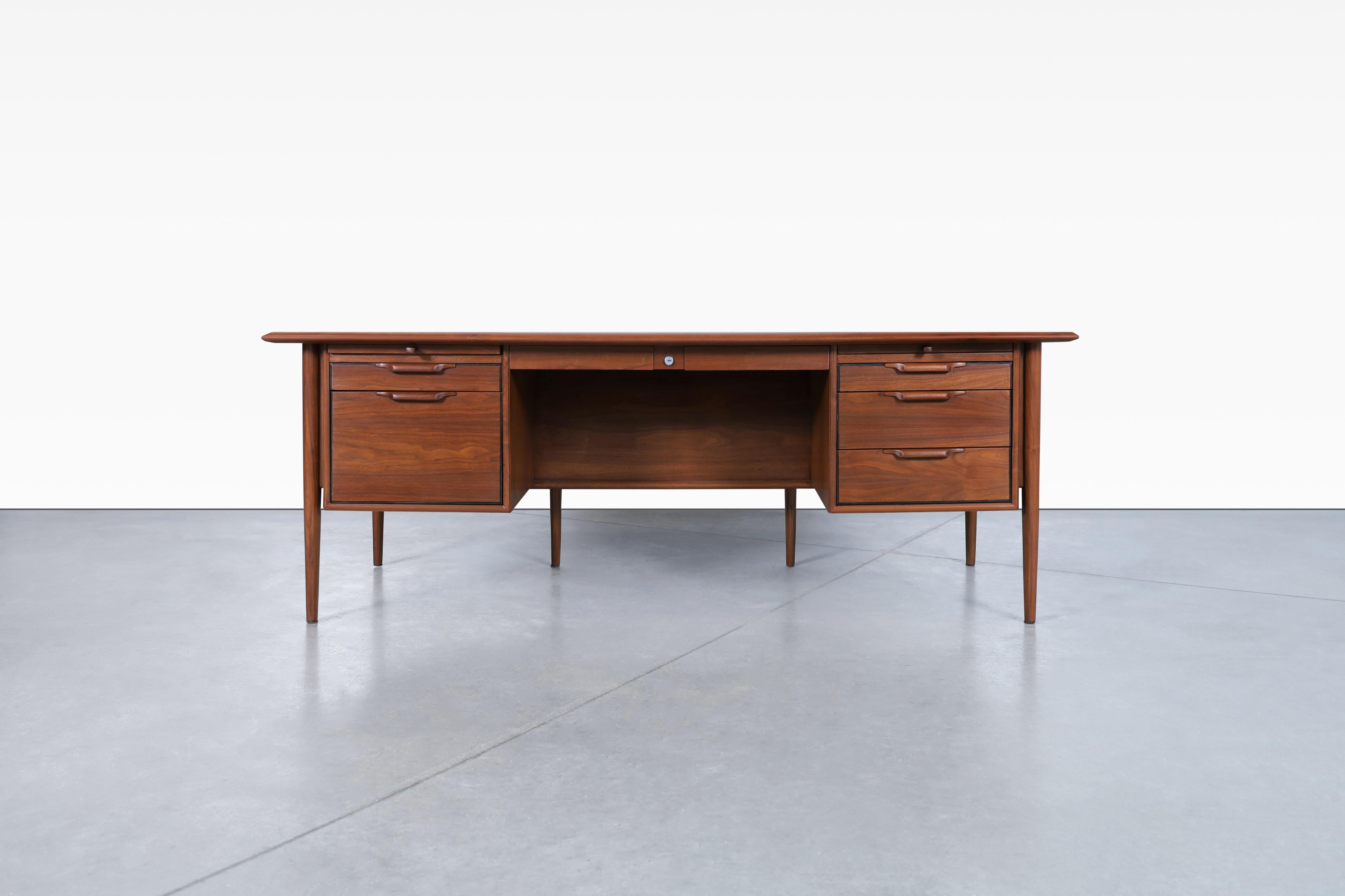 Fantastic mid-century walnut “Castillian” executive desk by Alma made in the United States, circa 1960s. Crafted with exquisite walnut and adorned with a luxurious leather top and back, this desk exudes a sense of elegance and refinement. The desk