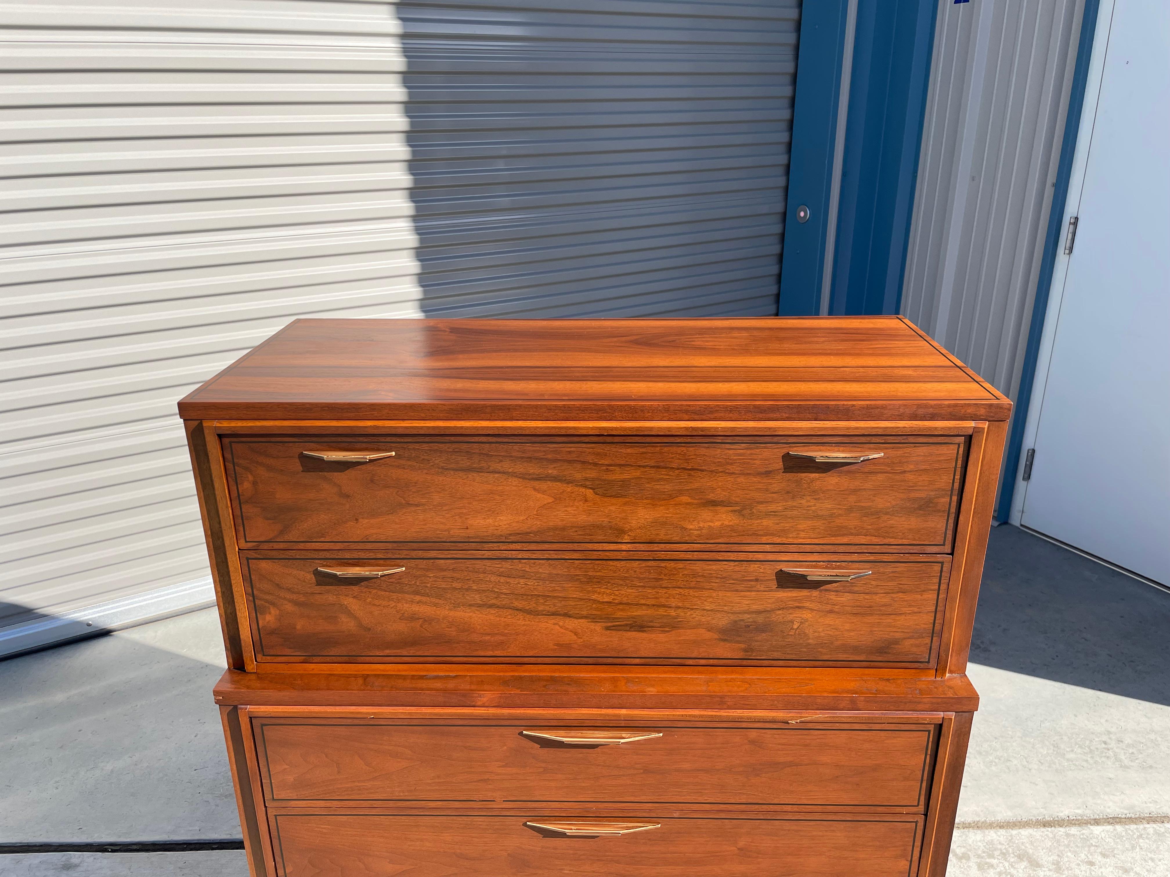 Stunning midcentury walnut highboy designed and manufactured by Kent Coffey Tempo in the United States circa 1960s. This vintage highboy features a walnut frame giving it an excellent color tone and design. It also comes with five pull-out drawers