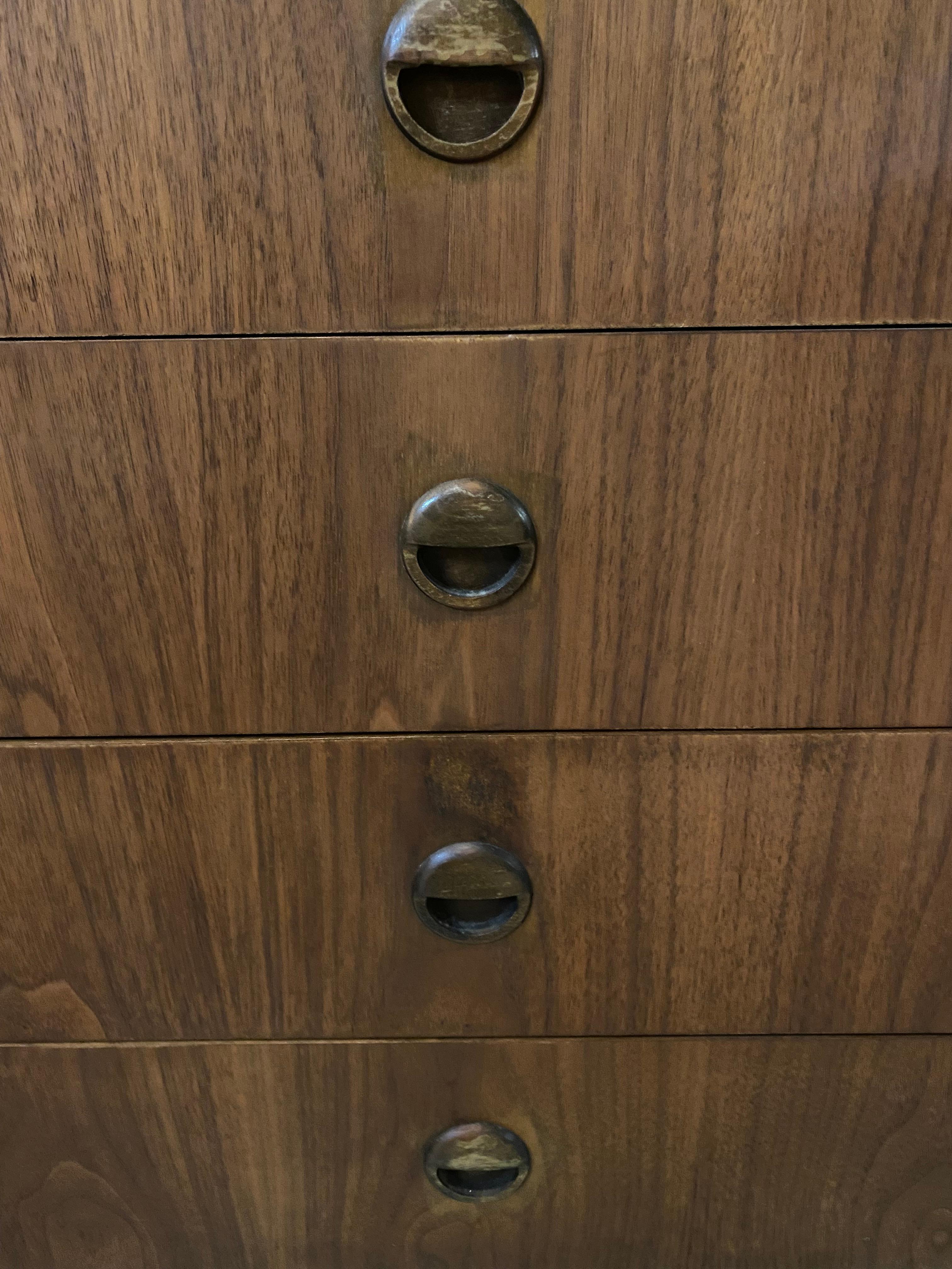 Questo mobile in noce moderno di metà secolo è dotato di scaffali aperti per l'esposizione e di quattro cassetti per l'archiviazione. I cassetti intagliati e la base in legno massiccio ne evidenziano il design pratico e funzionale. Realizzato in