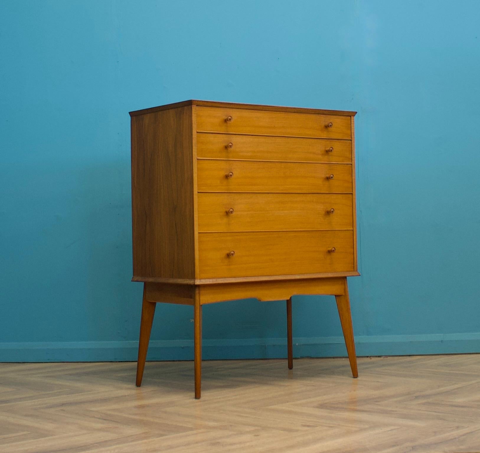 An impressive quality, tall walnut chest of drawers from Alfred Cox - retailed through Heal's during the 1950s
The bank of five drawers stands on long, tapered, splayed legs
The manner of construction of the legs means they are very sturdy and
