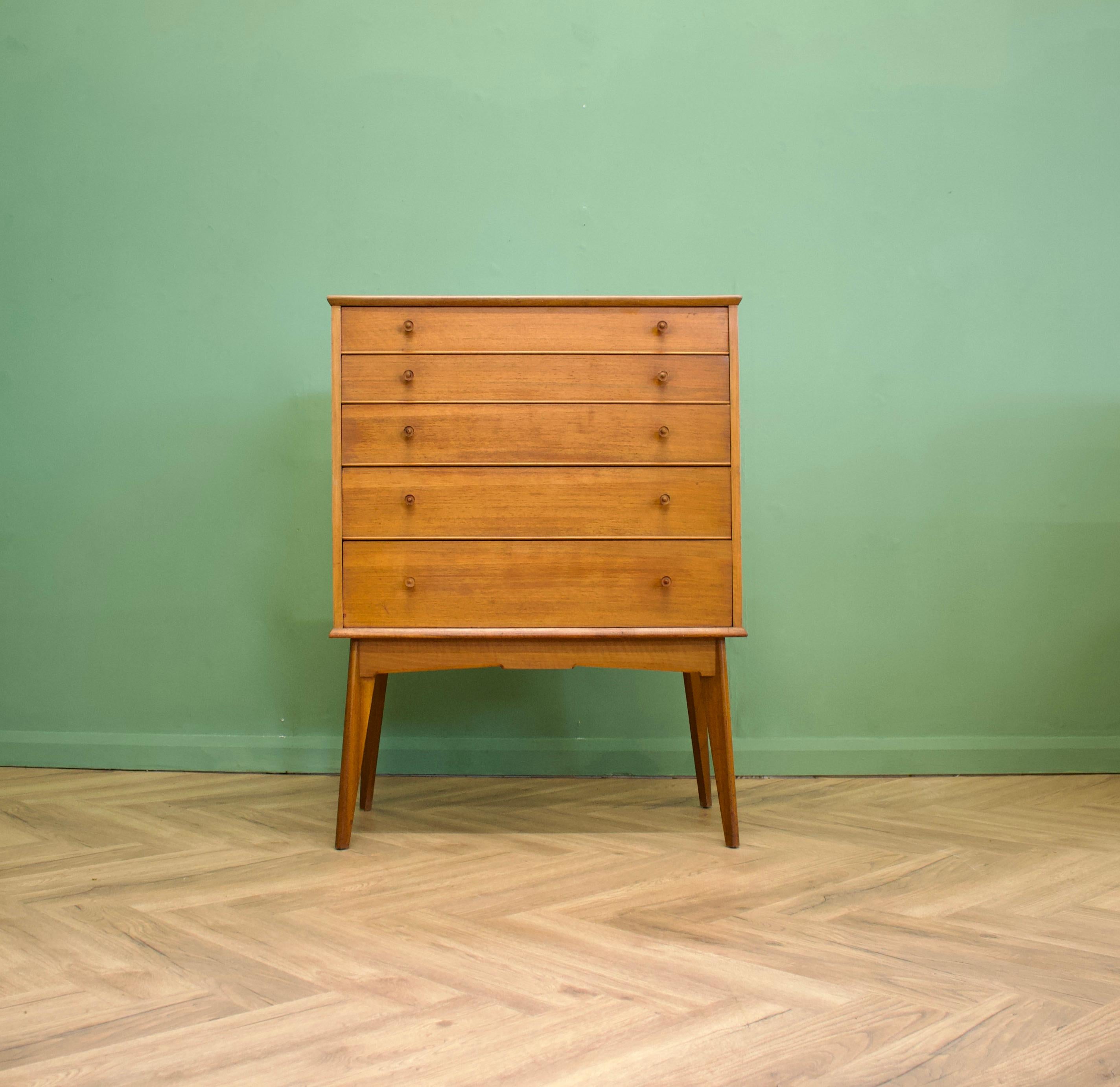 An impressive quality, tall walnut chest of drawers from Alfred Cox - retailed through Heal's during the 1950s
The bank of five drawers stands on long, tapered, splayed legs
The manner of construction of the legs means they are very sturdy and
