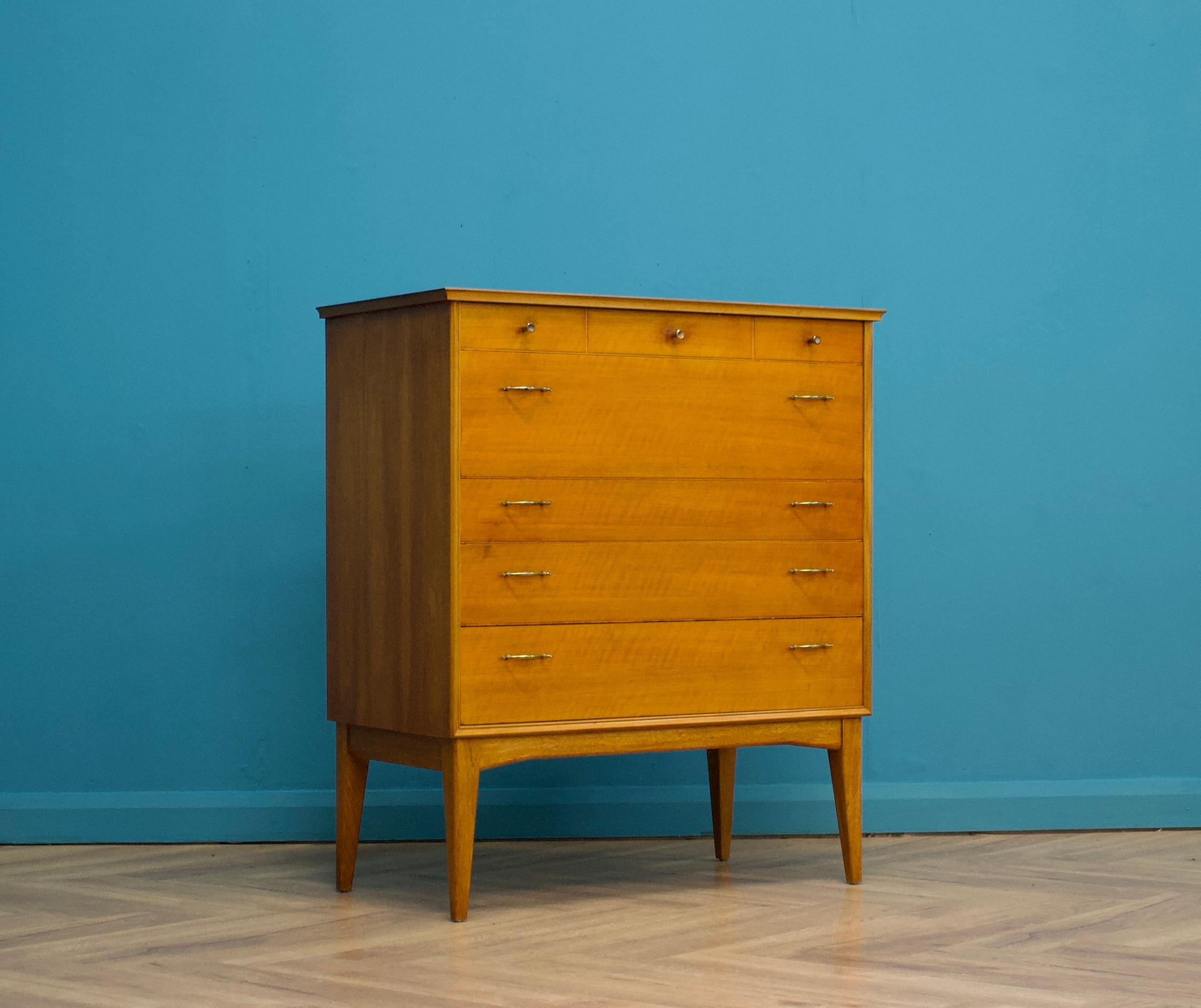 An impressive quality, tall walnut chest of drawers from Alfred Cox - retailed through Heal's during the 1950s
The bank of five drawers stands on long, tapered, splayed legs
