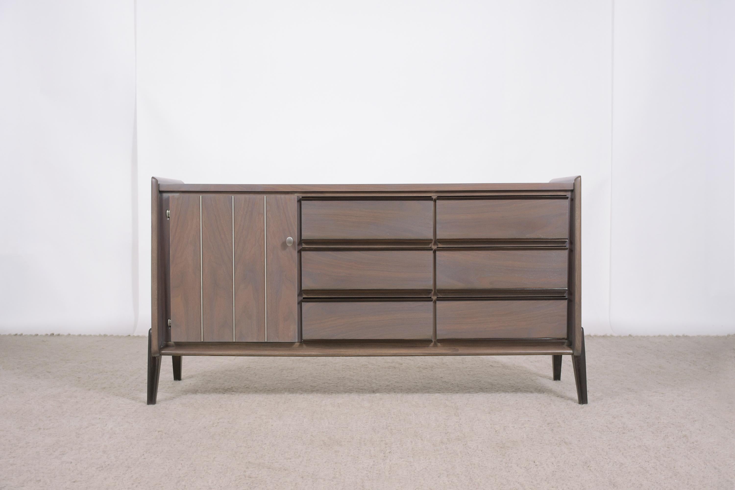 Embrace the iconic style of the 1960s with our beautifully restored Walnut Credenza, a piece that exemplifies the essence of mid-century design. This credenza, crafted by talented artisans and rejuvenated by our expert craftsmen, stands as a symbol