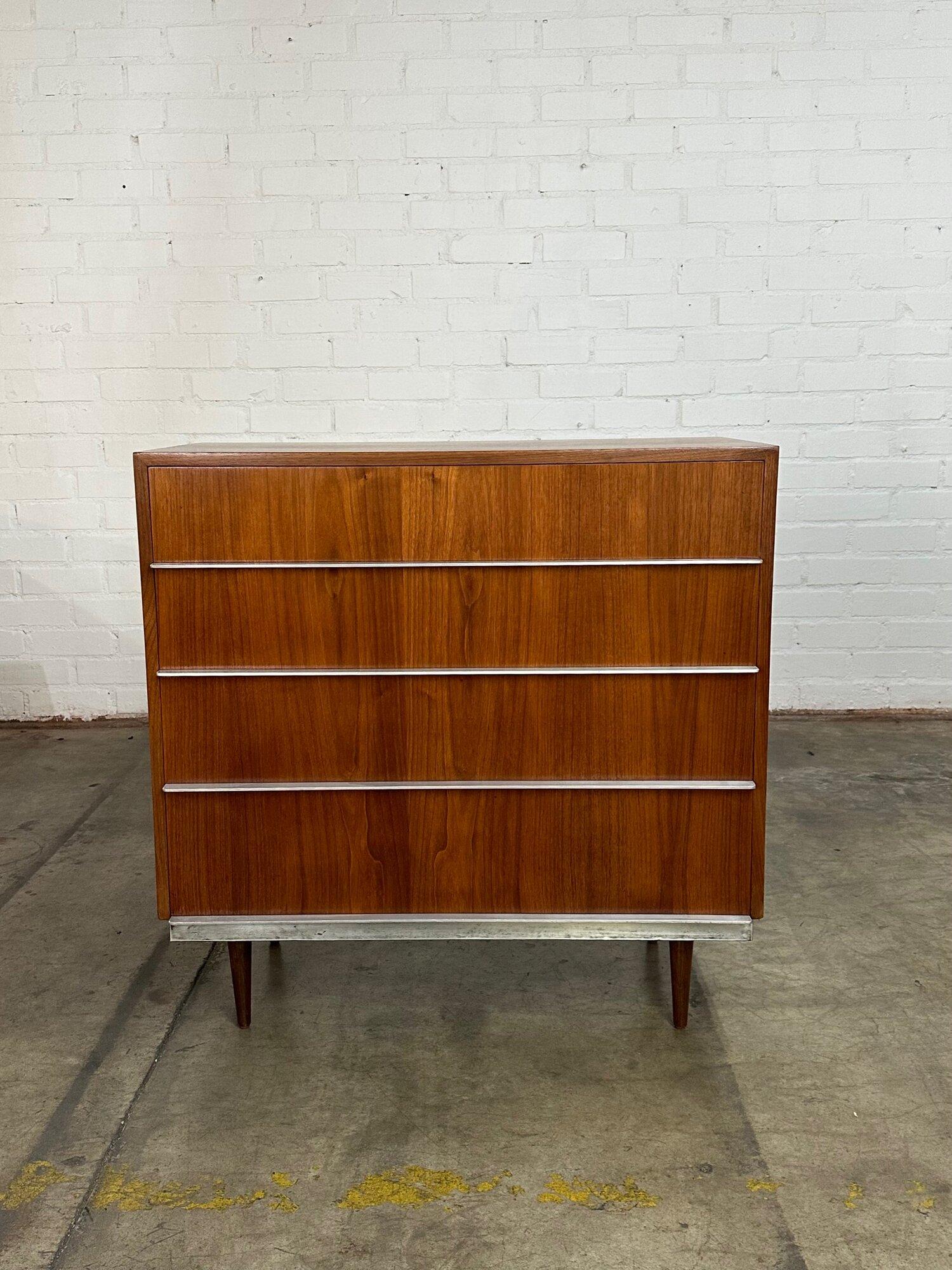 W37.5 D19 H38

Spacious 4 drawer chest made of walnut veneer with beautiful polished metal pulls across the drawer fronts. Each drawer slides smoothly is clean and spacious. The legs are solid walnut. This piece has been fully restored and is in