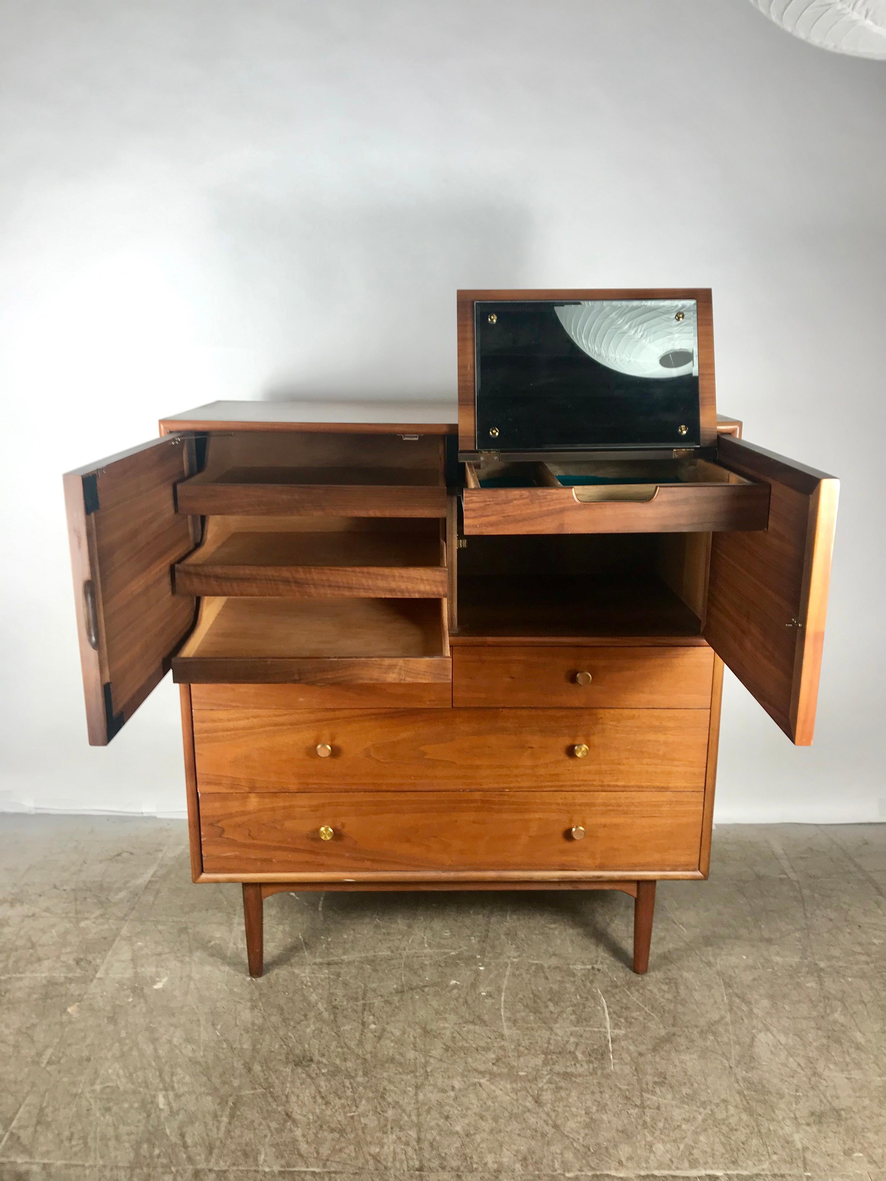 Midcentury walnut chest with concealed mirror, Kipp Stewart & Stewart McDougall for Drexal, superior quality and construction, amazing design, three generous size drawers to bottom, two doors, left side, three additional drawers, right side drawer