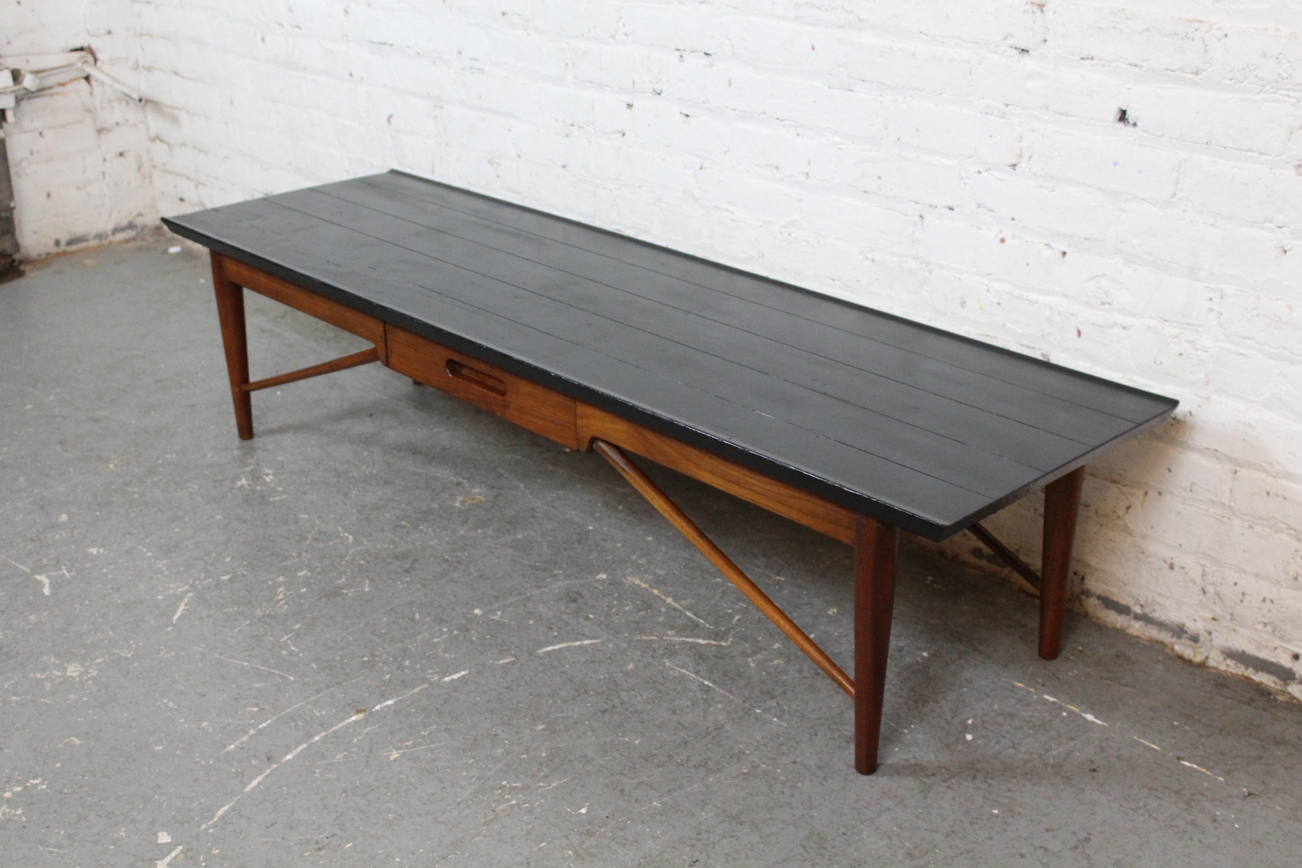 Élevez votre espace avec le style intemporel des meubles authentiques de la modernité du milieu du siècle ! Cette table basse rétro par excellence a été conçue et fabriquée par les maîtres ébénistes de la légendaire marque de meubles