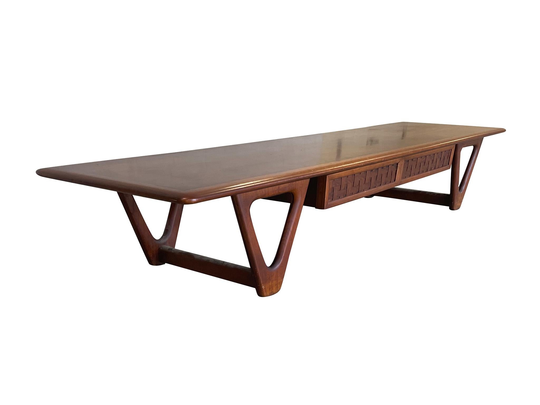 Handsome 1960s Perception coffee table, designed by Warren Church for Virginia-based Lane Company. Crafted in rich oak and walnut, the coffee table is designed with one large functional drawer with basketweave front and sculptural v-shaped legs. A