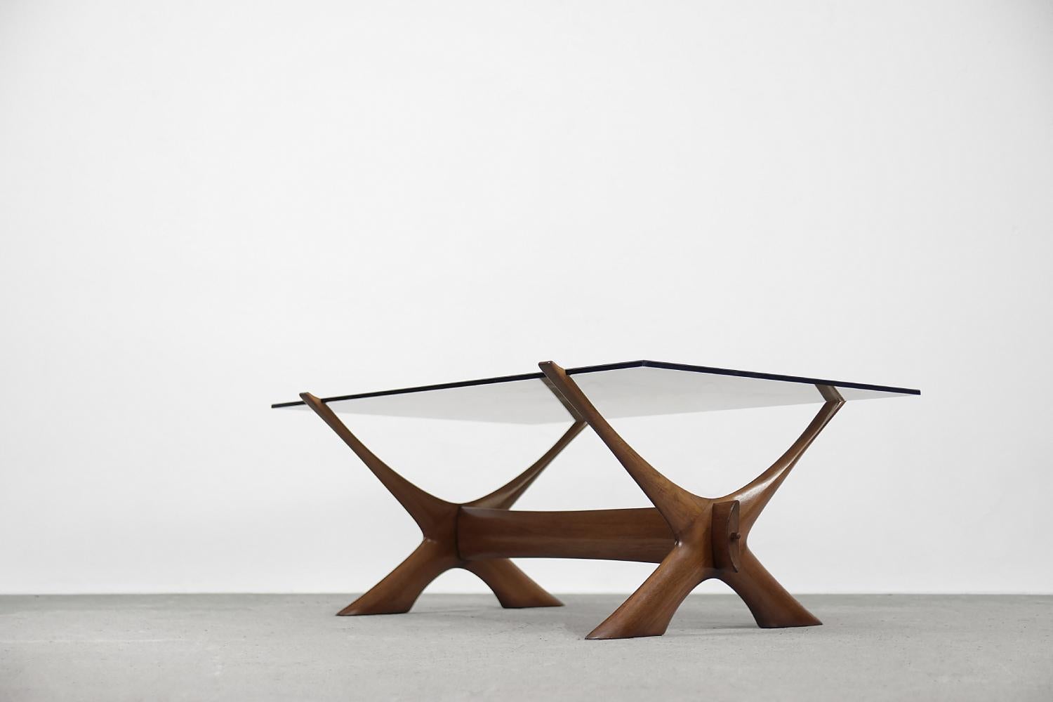 This organically sculptured Condor coffee table was designed by Fredrik Schriever-Abeln and manufactured by Örebro Glass in Sweden during the 1960s. The X-shape base was handcrafted from solid walnut. The distinct frame is contrasted by a linear