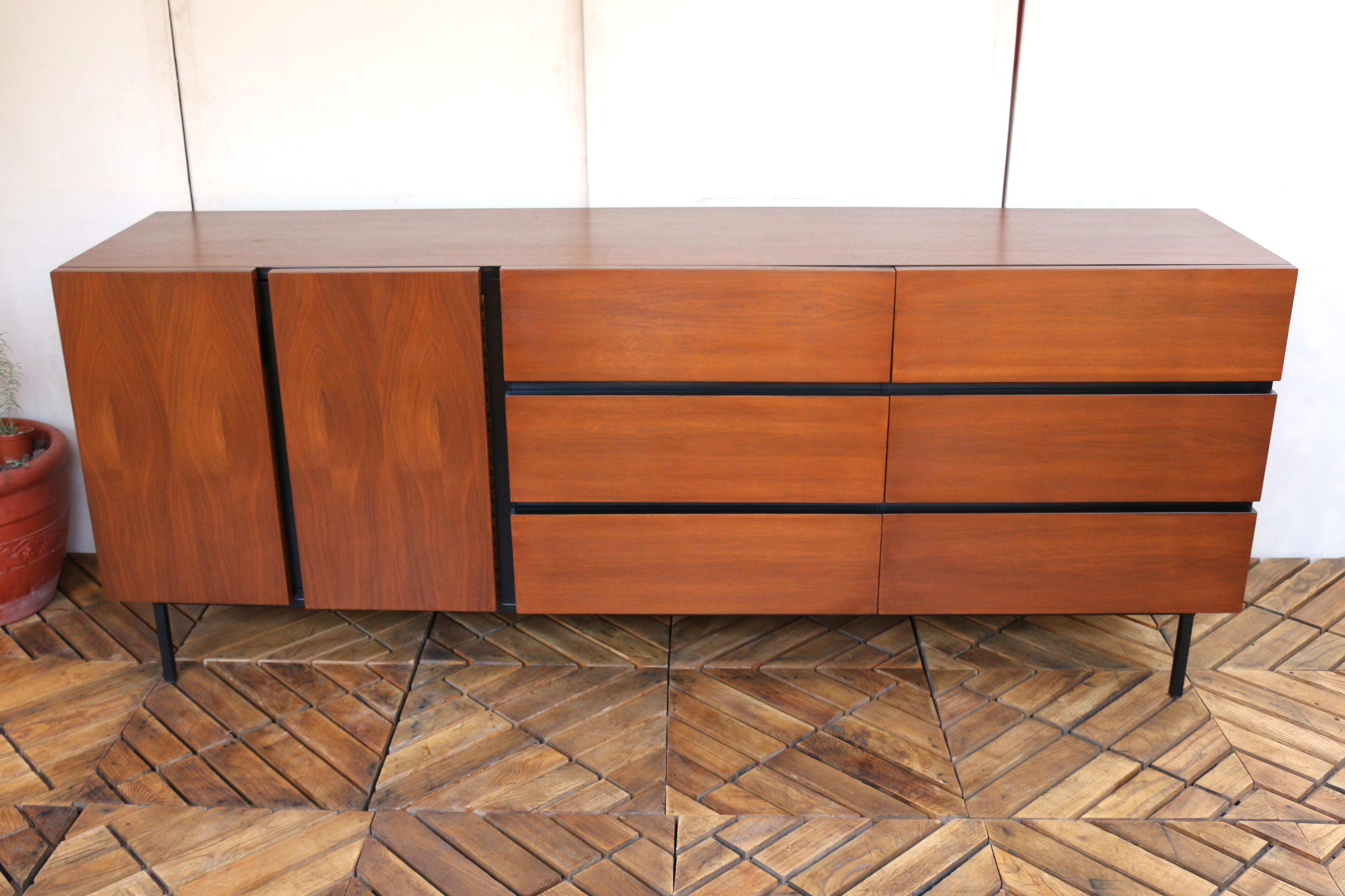 Stunning Mid-Century Modern walnut credenza characterized by its sleek lines and warm wood finis. This wonderful credenza is manufactured by American of Martinsville, it has the maker’s mark in a drawer. It has been refinished and is very well kept.
