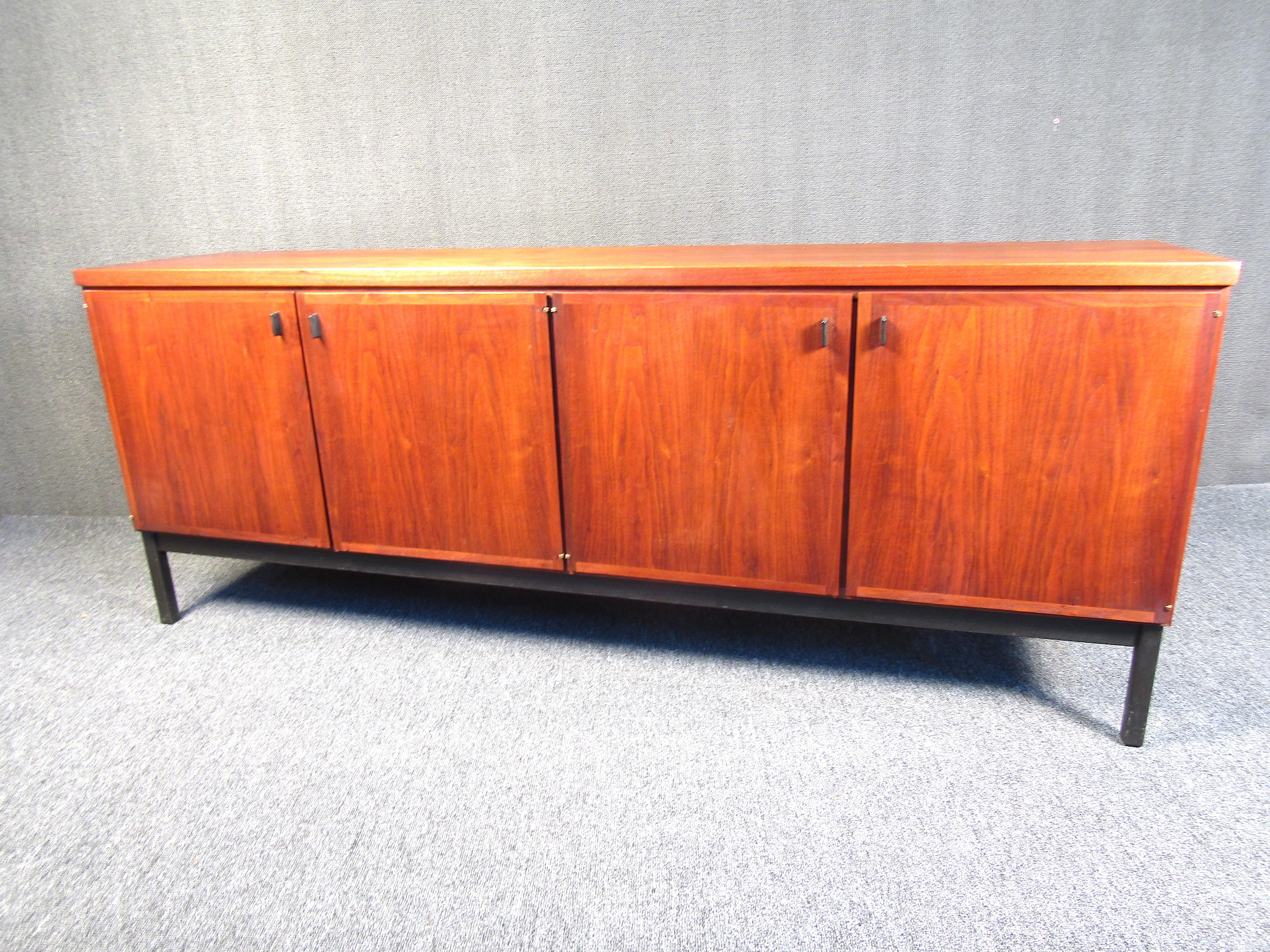 This beautiful walnut credenza features plenty of storage underneath as well as a beautiful dark grain pattern as well. Perfect for any dining room or side accent room. With sturdy construction, this piece will be a valued possession for years to