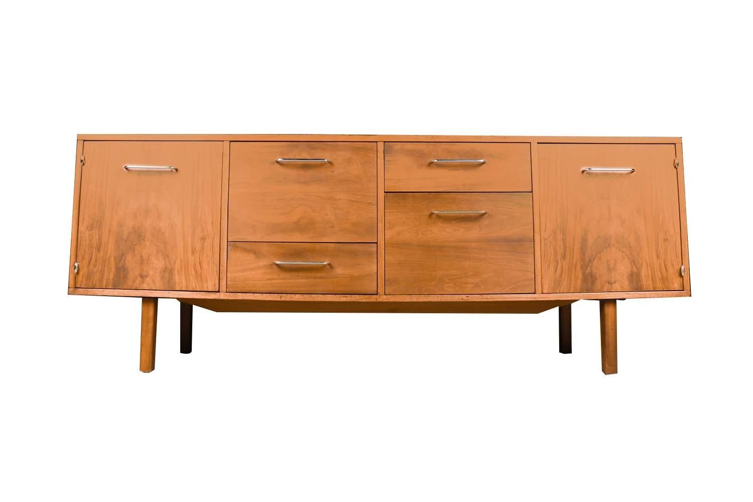 An exceptional and solid mid-century walnut file cabinet/credenza by B. L. Marble Furniture Company Jens Risom Style. This absolutely stunning piece features gorgeous walnut wood grain, stylish metal pulls and door hinges, a low profile, and sits