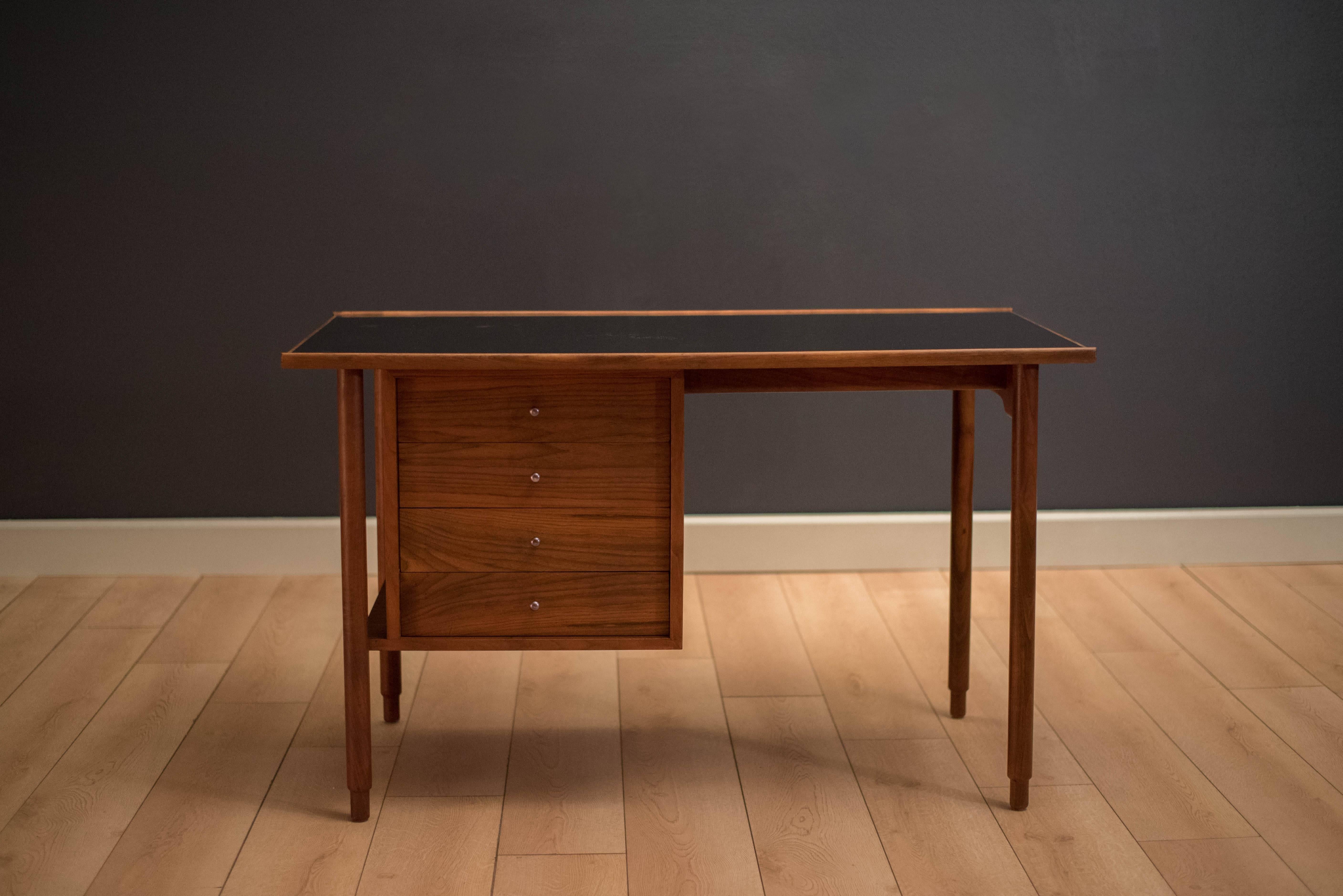 Vintage Concourse collection desk designed by Charles Pechanec for St. John Manufacturing Company. This piece features a raised edge top and signature walnut legs. Includes four storage drawers and a black laminate top for easy maintenance. Also,