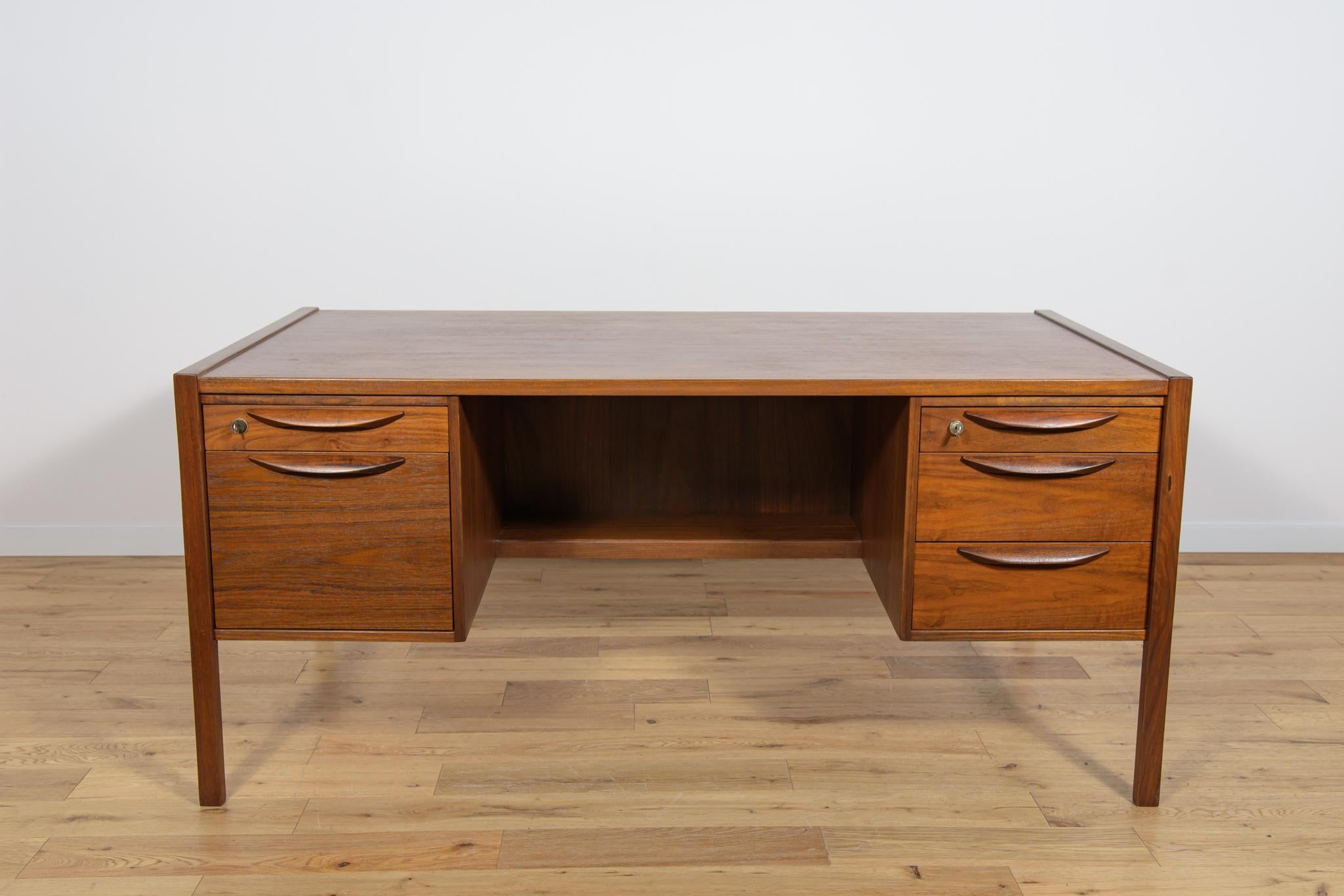 A large desk made of walnut wood from the 1960s, designed by Jens Risom for the American manufactory Jens Risom Design. Desk with two drawer modules. There are two drawers in the left module, and three drawers in the right module, locked with a key.