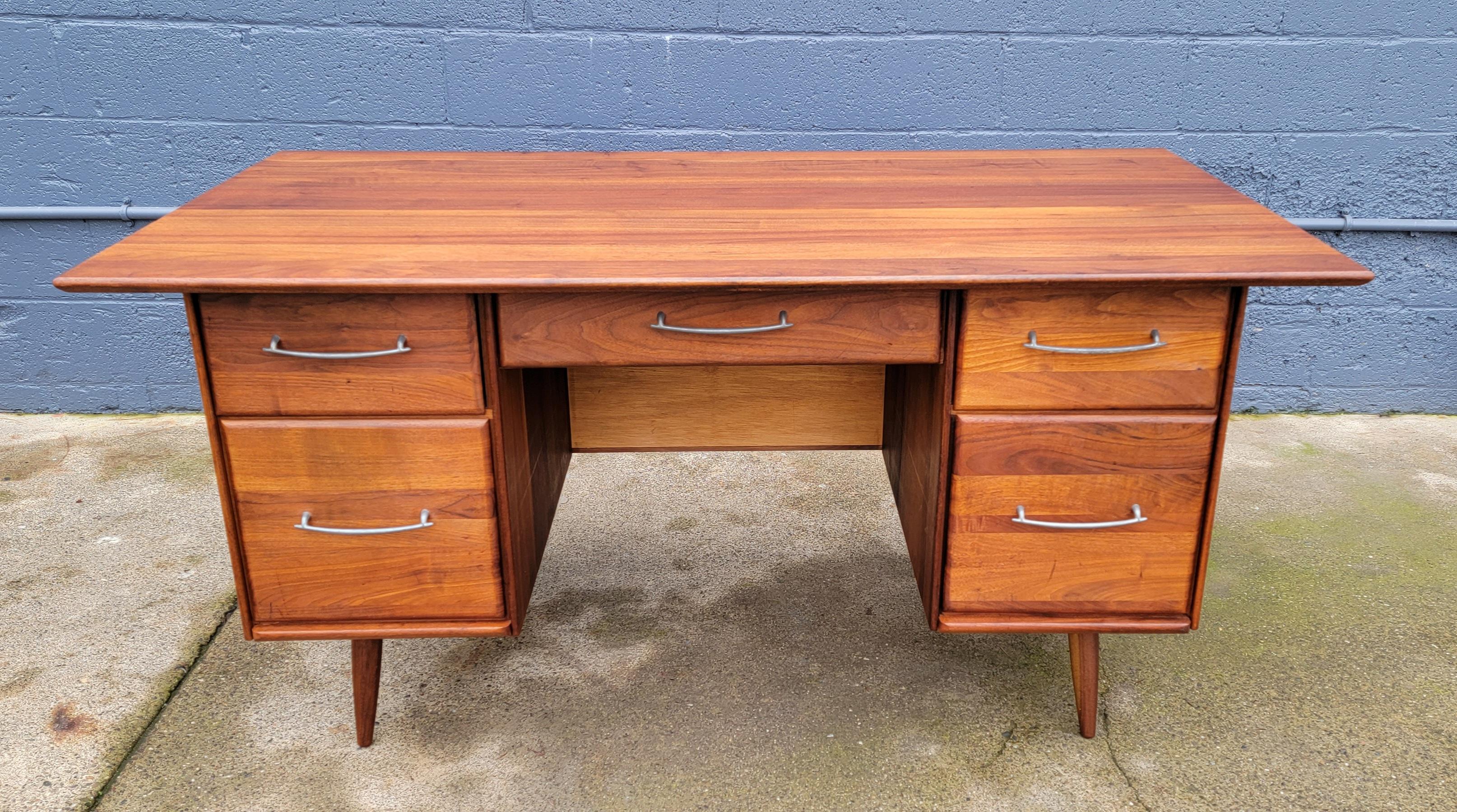 Mid-Century Modern desk by Prelude Furniture. Circa. 1960's. Quality crafted with the majority of woods in solid walnut and solid oak. Exceptional wood grain with depth and glow to original finish. Ample storage with large drawers. Classic peg leg