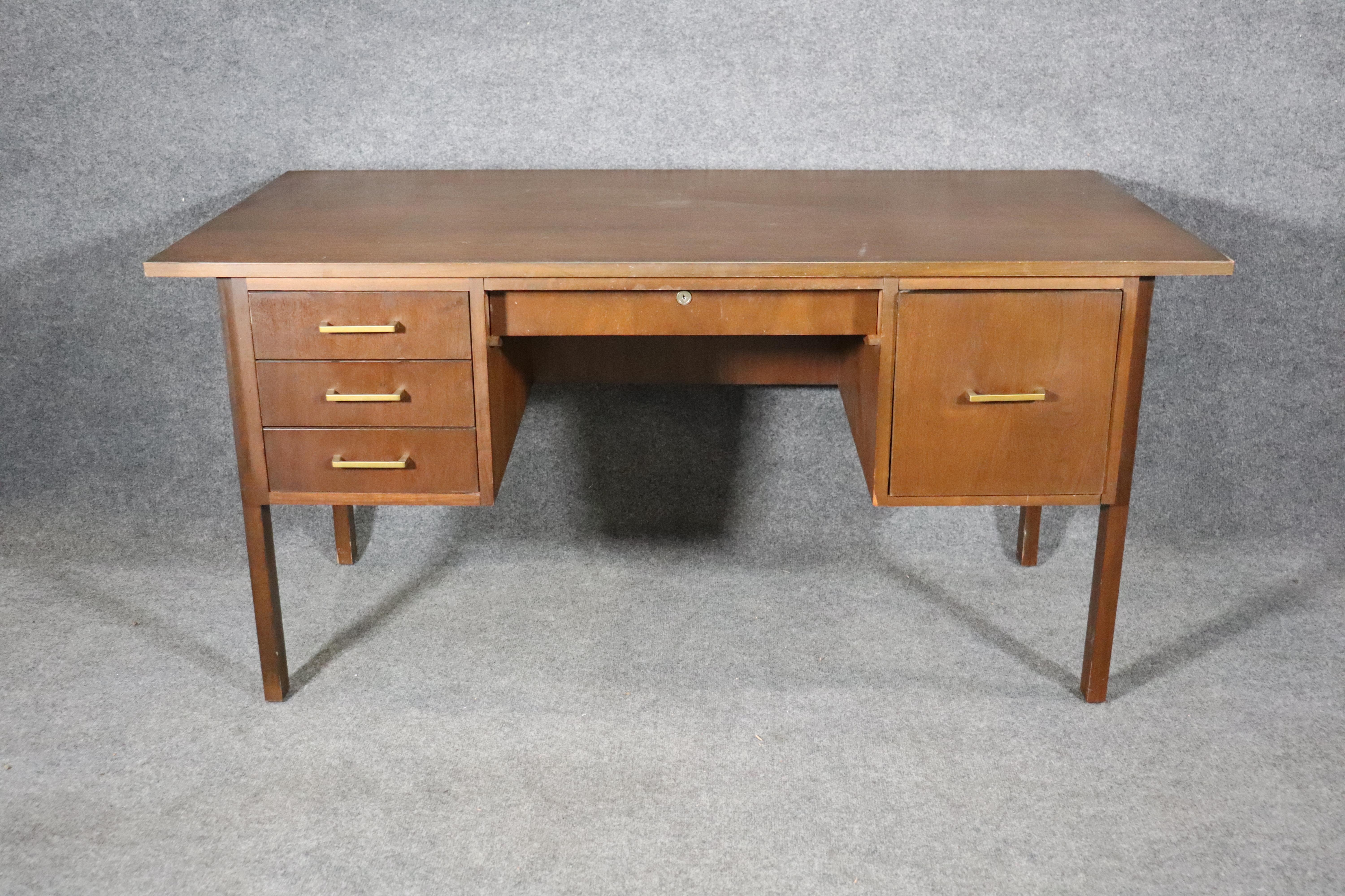 Bureau moderne du milieu du siècle dernier fabriqué par l'Indiana Desk Company. Grand bureau en noyer et cinq tiroirs avec poignées en laiton.
Veuillez confirmer le lieu NY ou NJ