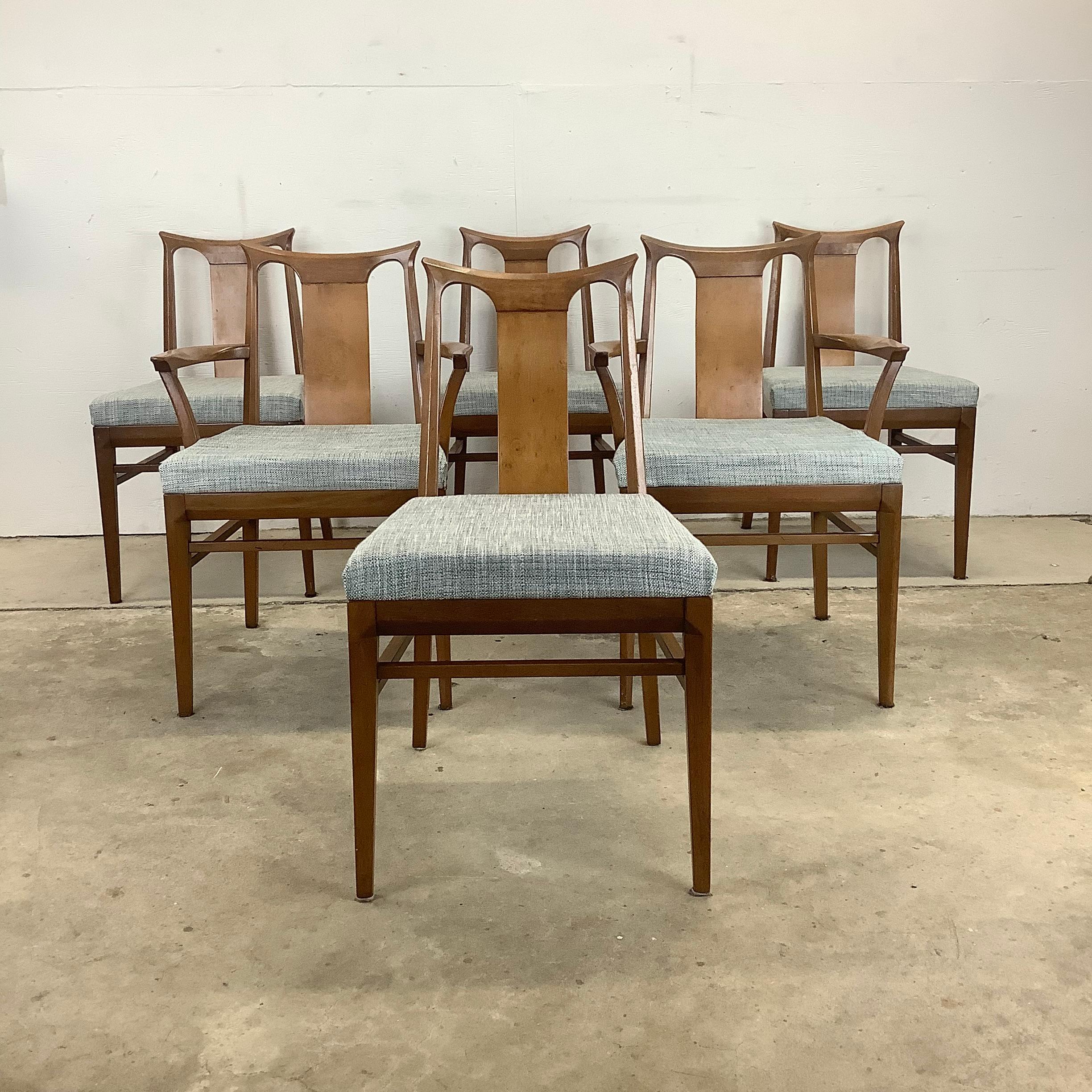 This matching set of six Mid-Century Modern dining chairs feature vintage walnut finish, sculptural seat backs, and comfortable upholstered seats. The comfortable and sturdy design of this set of six vintage dining chairs make them an excellent