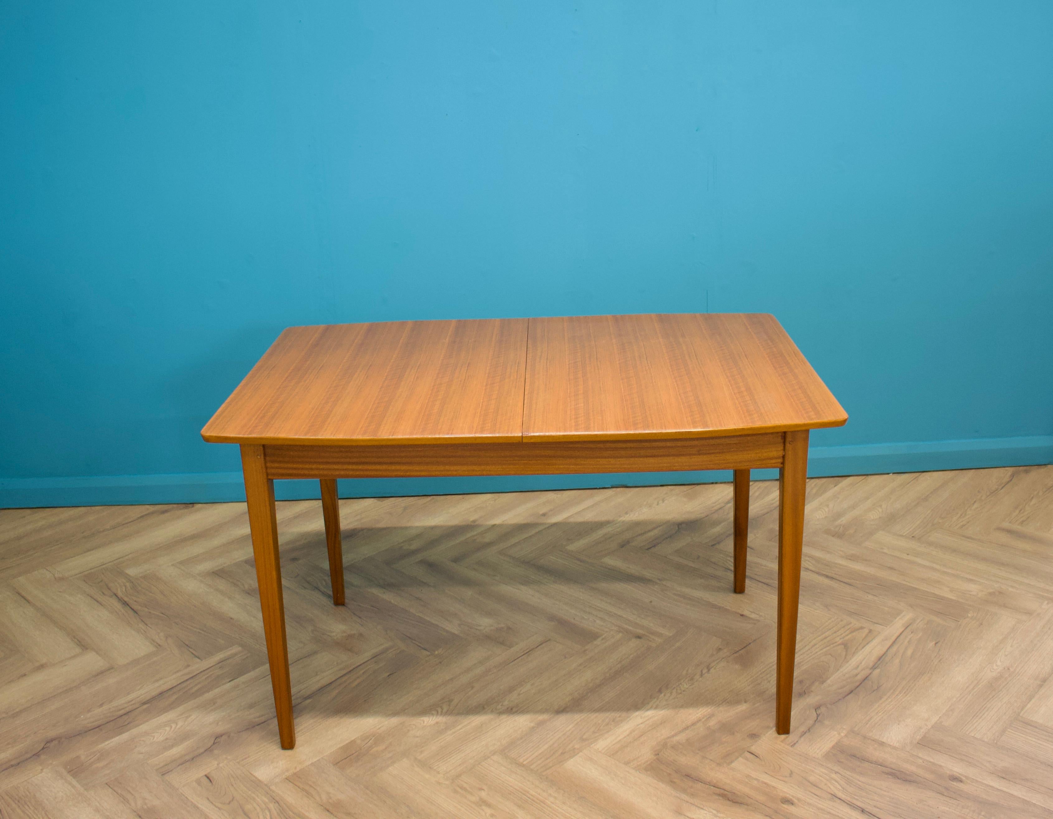 A walnut extending dining table possibly by Younger, circa 1960s

Extended width 168 cm

The extending leaf is stored underneath the top and opens via a swing mechanism