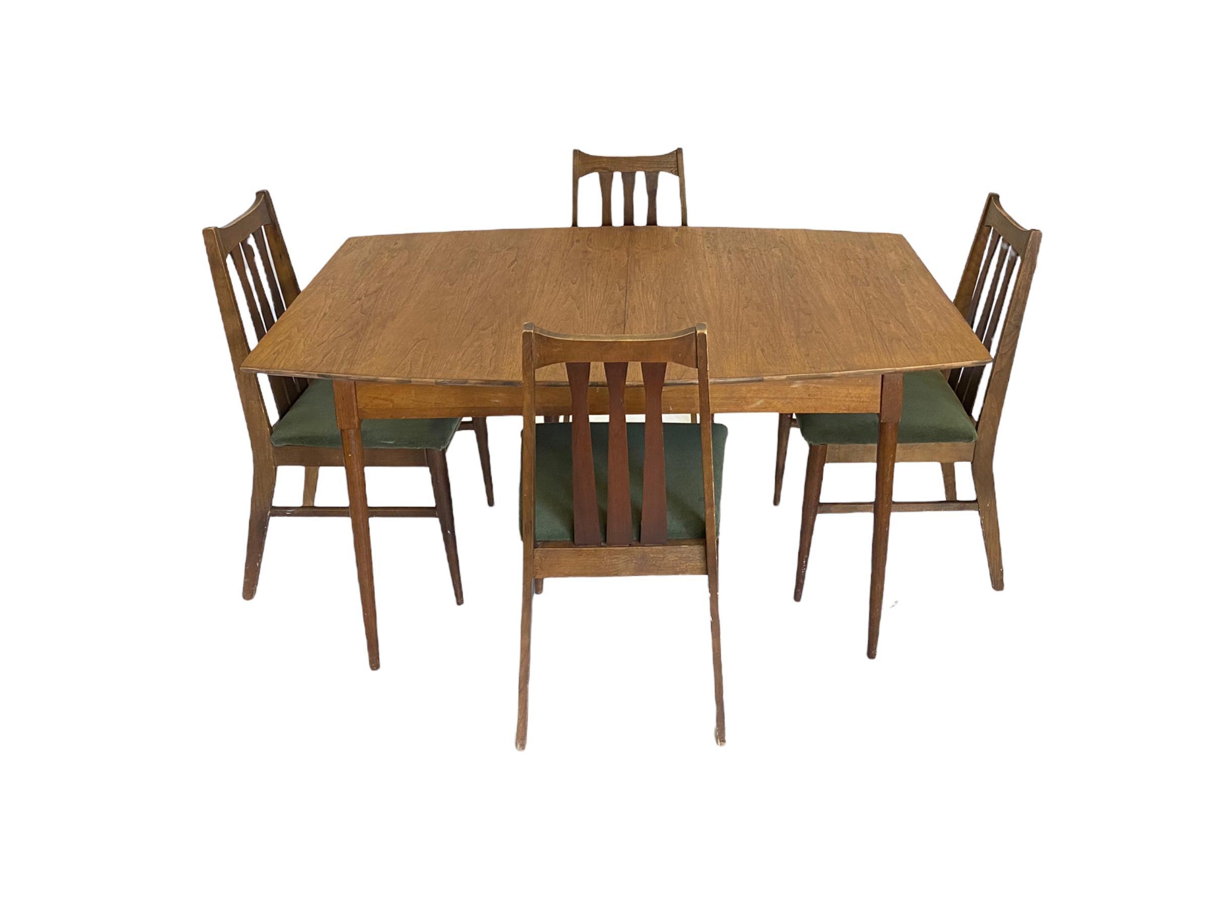 Mid-Century Modern dining set with walnut table and american made walnut dining chairs. The table has been refinished. The chairs feaure bowtie shape splat back and are recently reupholstered in dark green velvet-like material. Good vintage