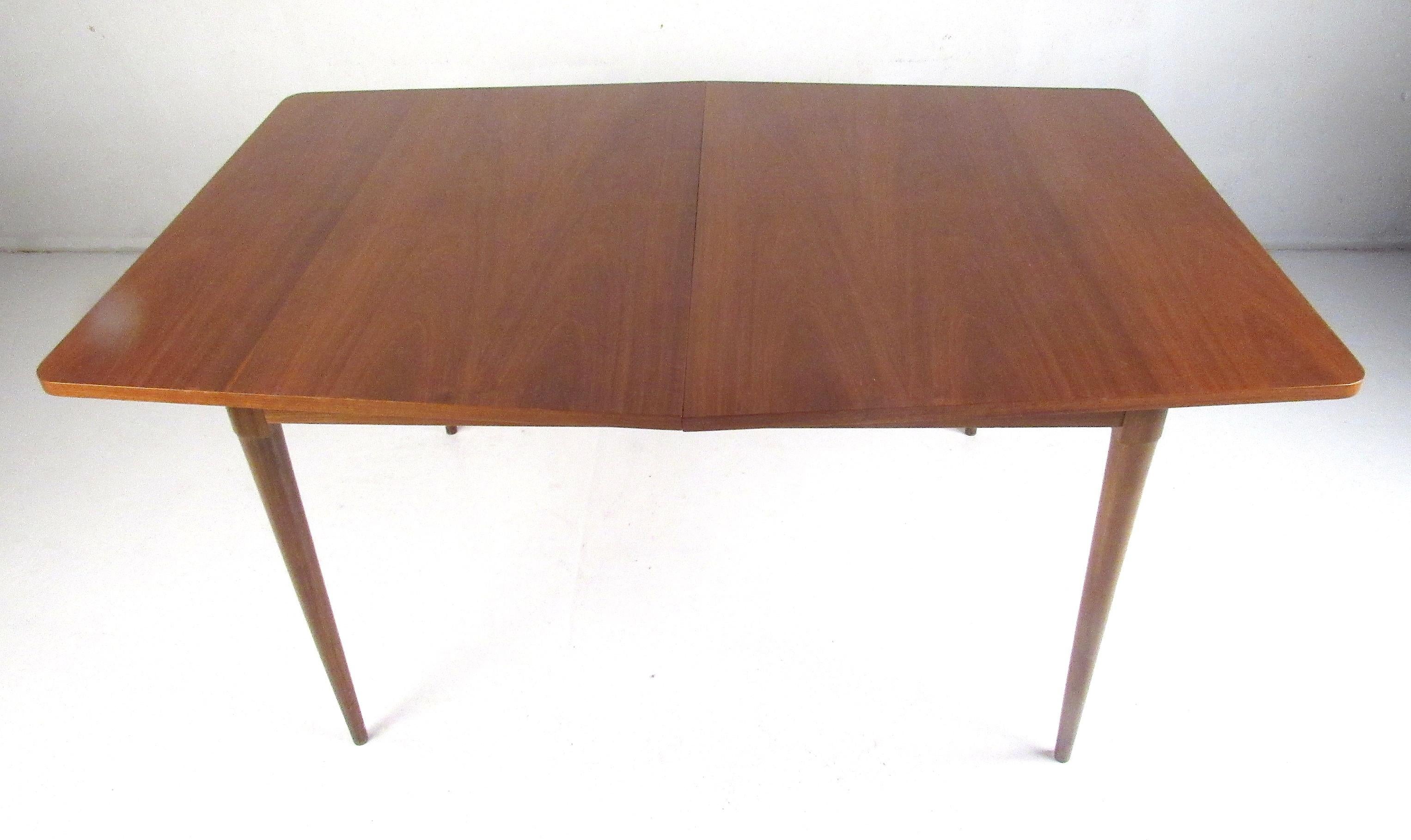 Clean lines and simple detailing define this Mid-Century Modern walnut dining table. The table expands from 60