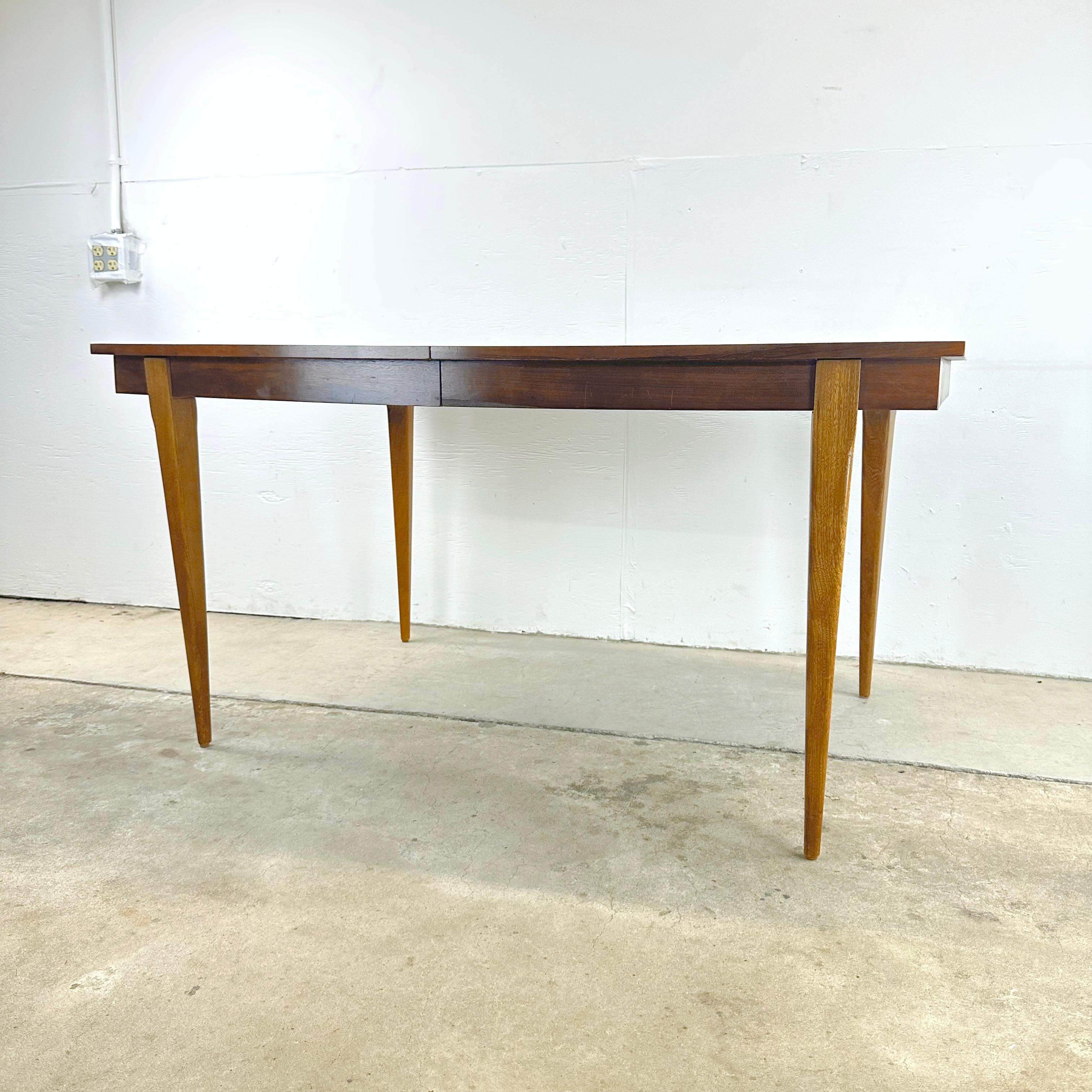 Are you on the hunt for a dining table that seamlessly combines classic design, versatility, and a touch of mid-century charm? Look no further than this 1960s Mid-Century Modern Walnut Dining Table with Leaf, attributed to the Young Manufacturing