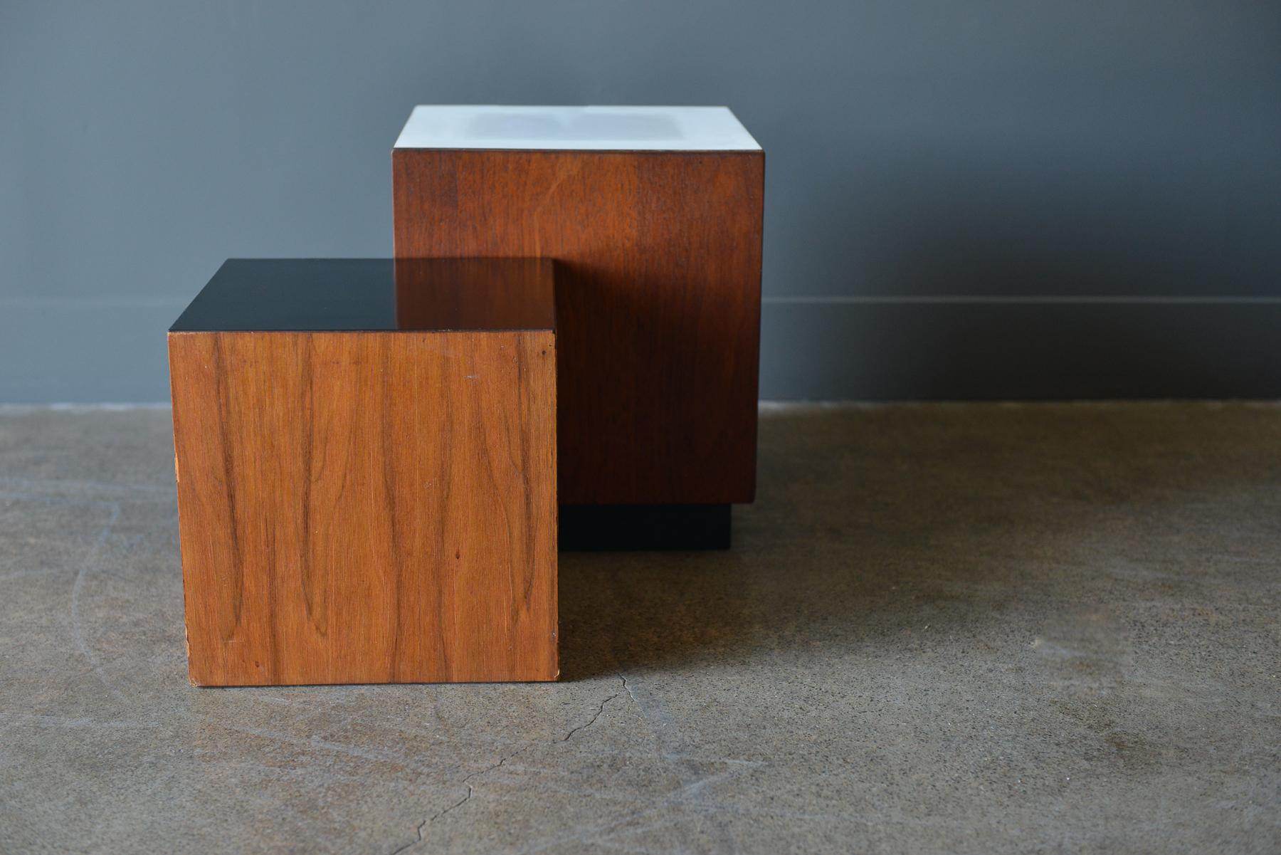 Midcentury walnut display cubes or side tables, circa 1970. Walnut with white and black laminate sides, they can be used together as small side tables, or as display pedestals for artwork or sculpture. Large measures 12 x 12 x 14 H and small